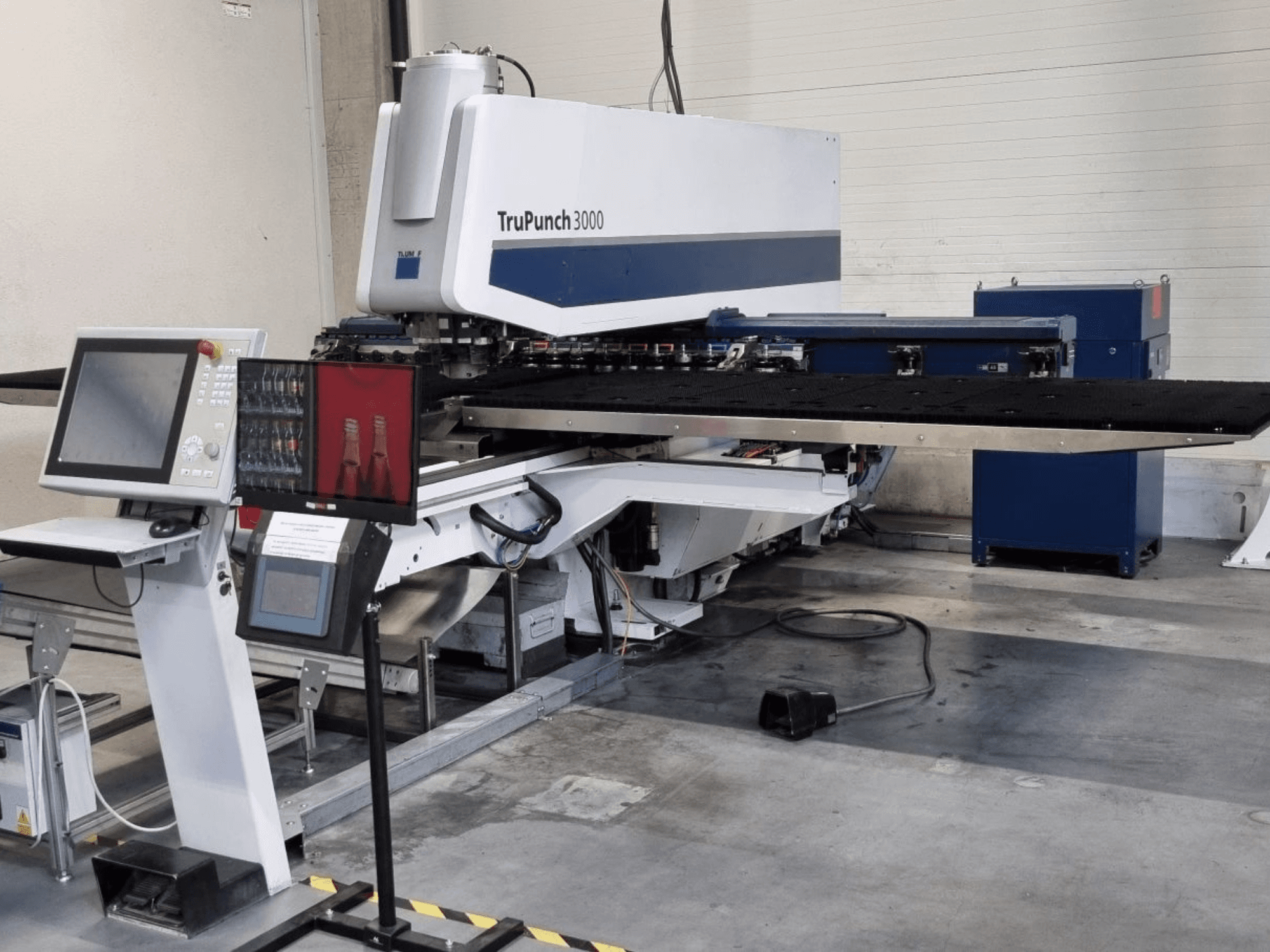 Poinçonneuse CNC TRUMPF TruPunch 3000 vue de face, avec son panneau de commande et sa grande table de poinçonnage.