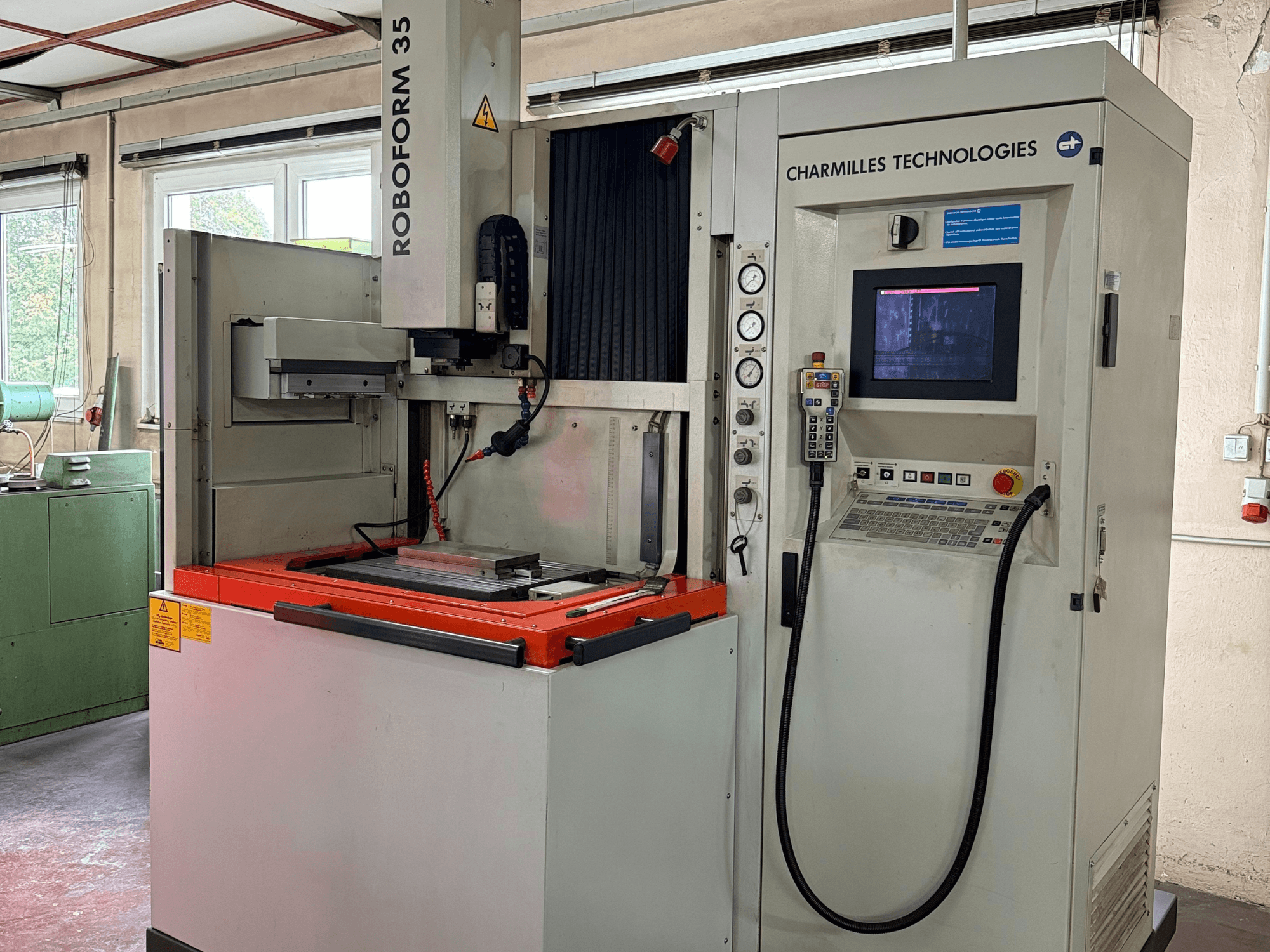 Machine Roboforn 35 de Charmilles Technologies, vue de face, montrant le panneau de commande, les outils montés et les étiquettes de sécurité.