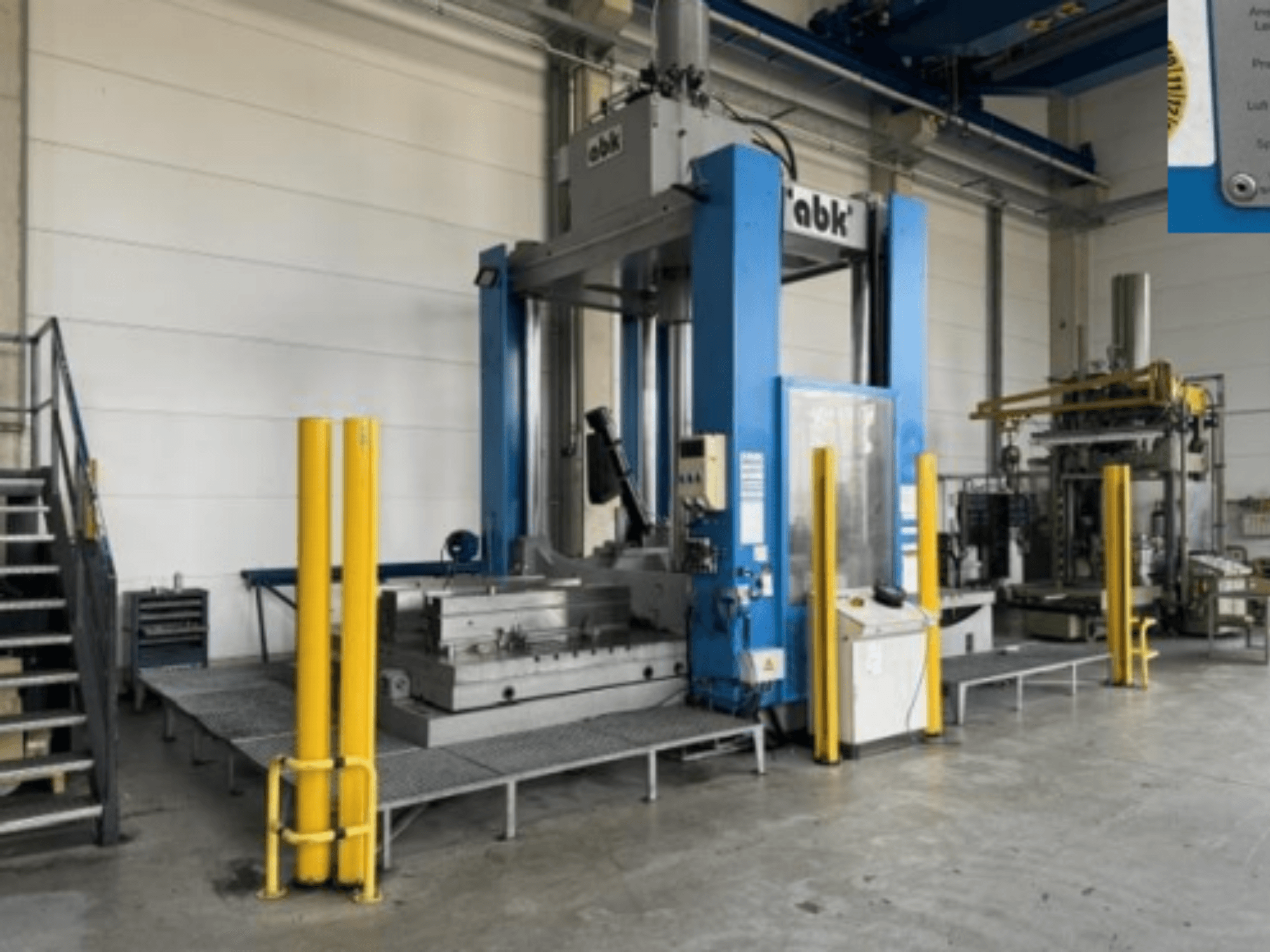 Machine-outil ABK abk-TP-20-250 vue de face, avec ses barrières de sécurité jaunes et les équipements d'usinage qui l'entourent.