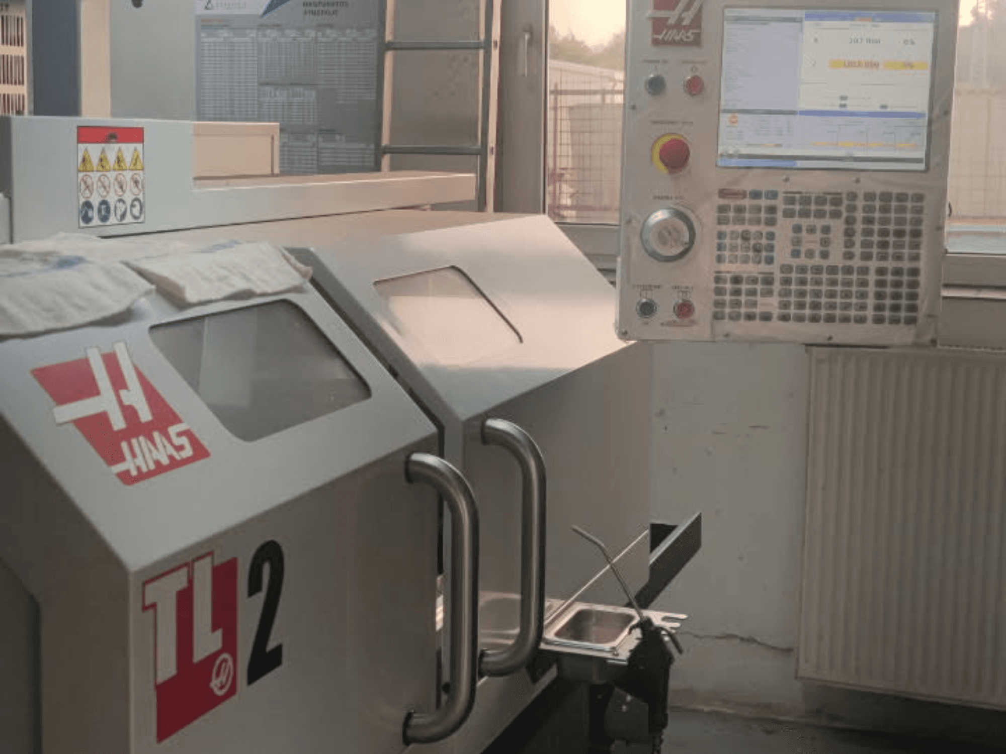 Vue avant du tour horizontal Haas TL-2, avec le panneau de commande, le boîtier métallique et les panneaux de sécurité.