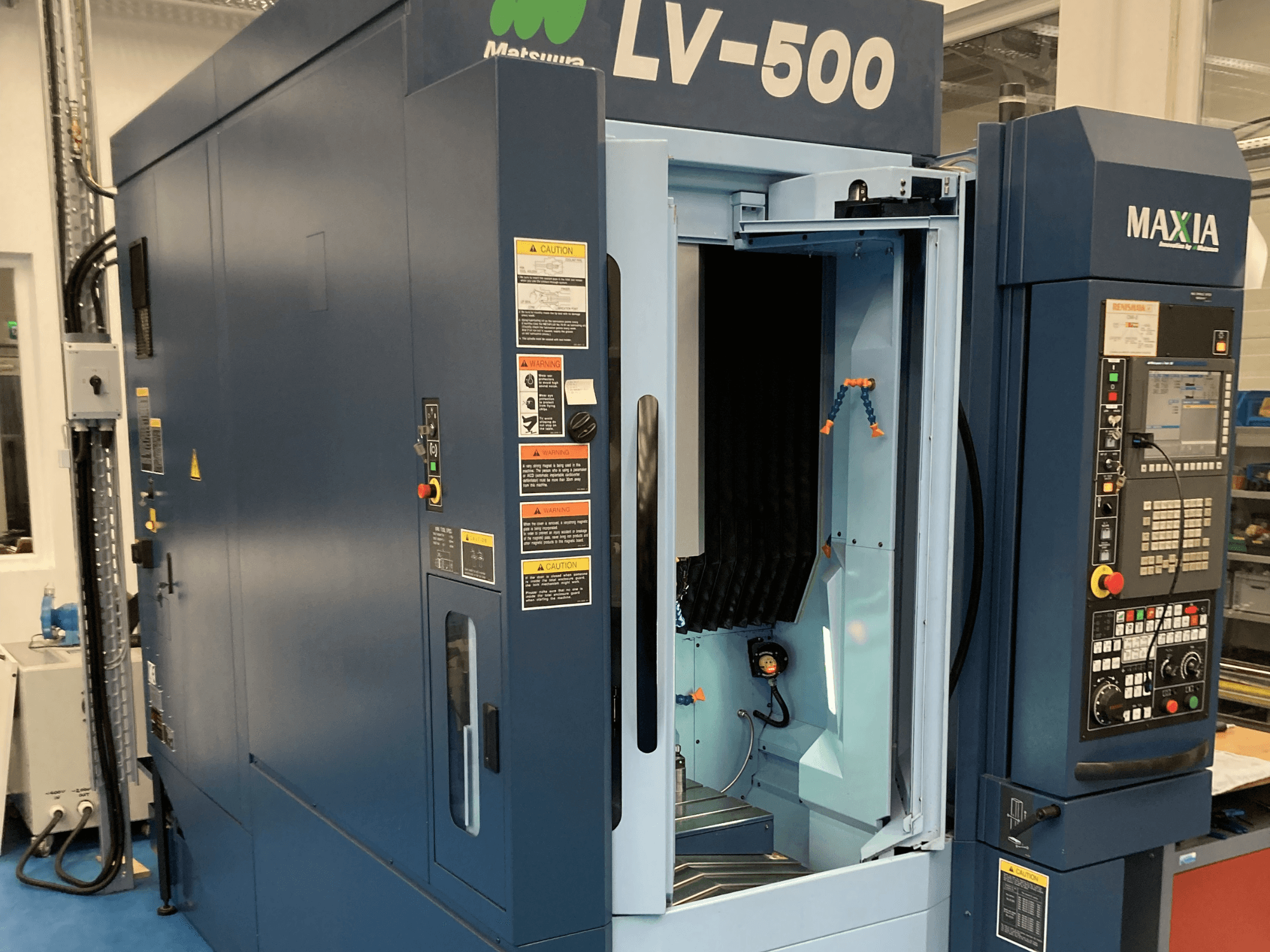 Centre d'usinage vertical Matsuura LV-500 présenté en vue de face, avec une porte ouverte et un panneau de commande avec des boutons.