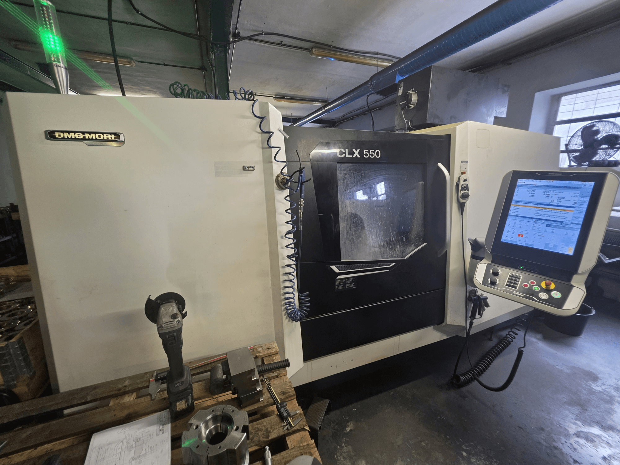 Tour horizontal DMG MORI CLX 550 V3, vue de face montrant le panneau de commande, les outils de coupe et le châssis de la machine.