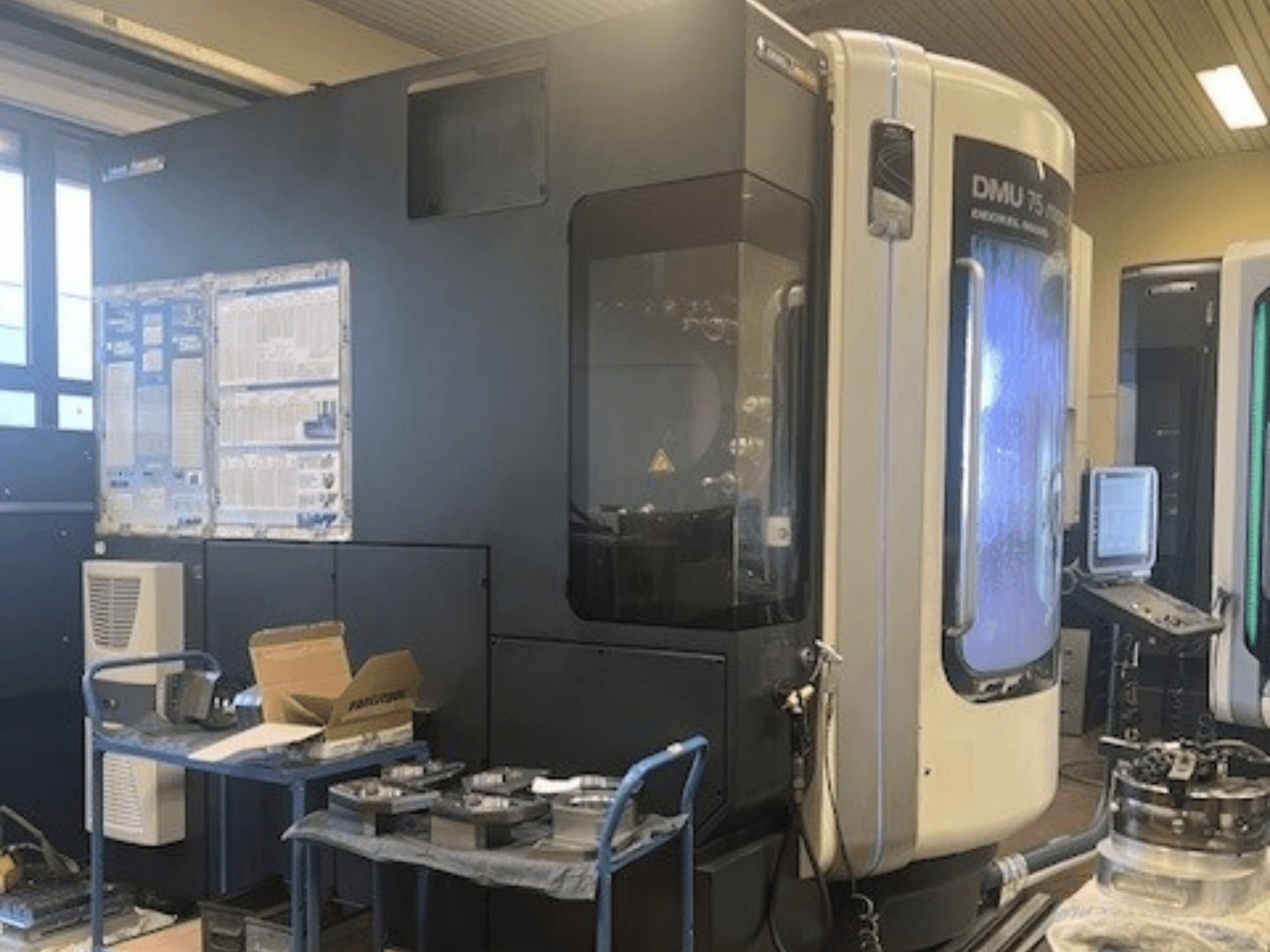 Centre d'usinage universel DMG Mori Seiki DMU 75 monoBlock, vue de face, présentant le panneau de commande, le système d'arrosage et l'espace de travail.