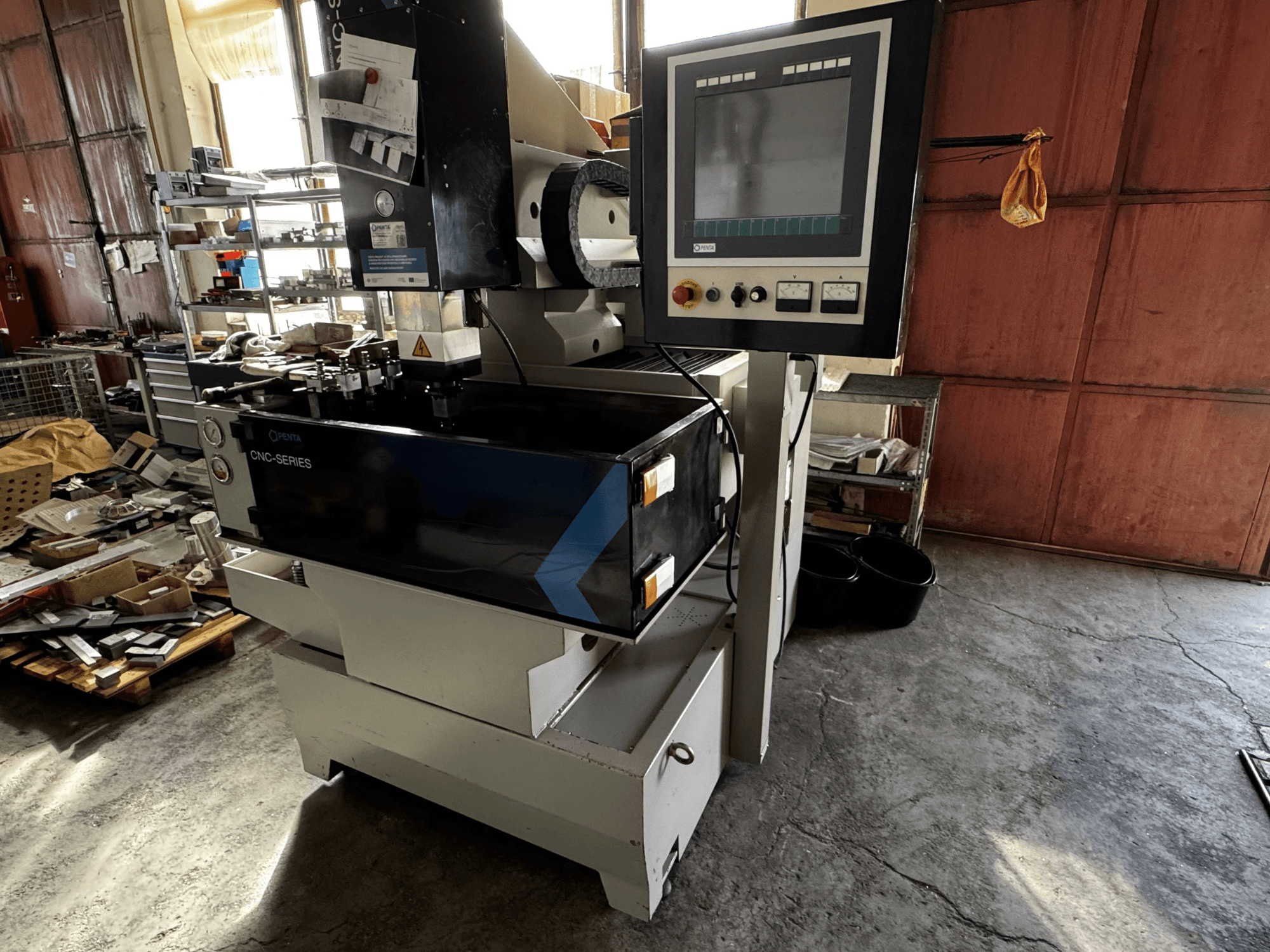 Machine d'électroérosion à enfonçage CNC PENTA 433GS, vue de face. Affiche le panneau de commande, le porte-électrode et la table de travail métallique.