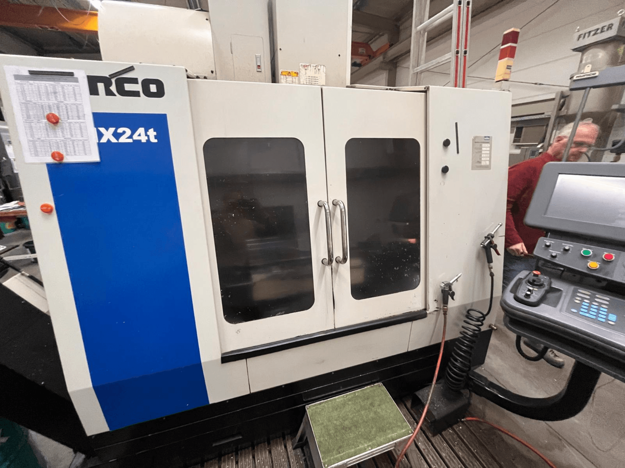 Centre d'usinage vertical Hurco, modèle VX24t, présenté de face avec panneau de commande et portes transparentes.