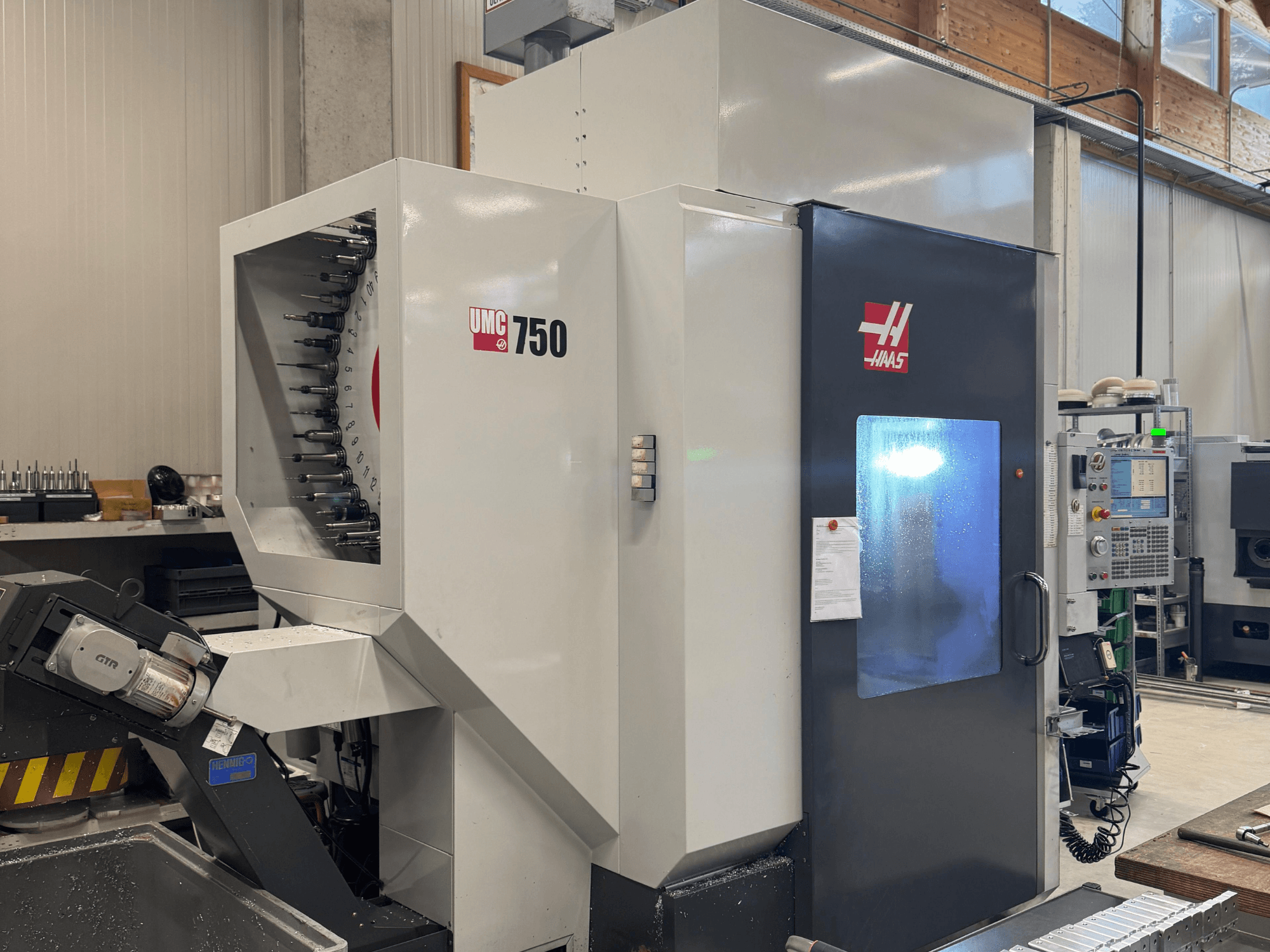 Centre d'usinage Haas UMC 750, vue de face, présentant le porte-outil et le panneau de commande dans un atelier.