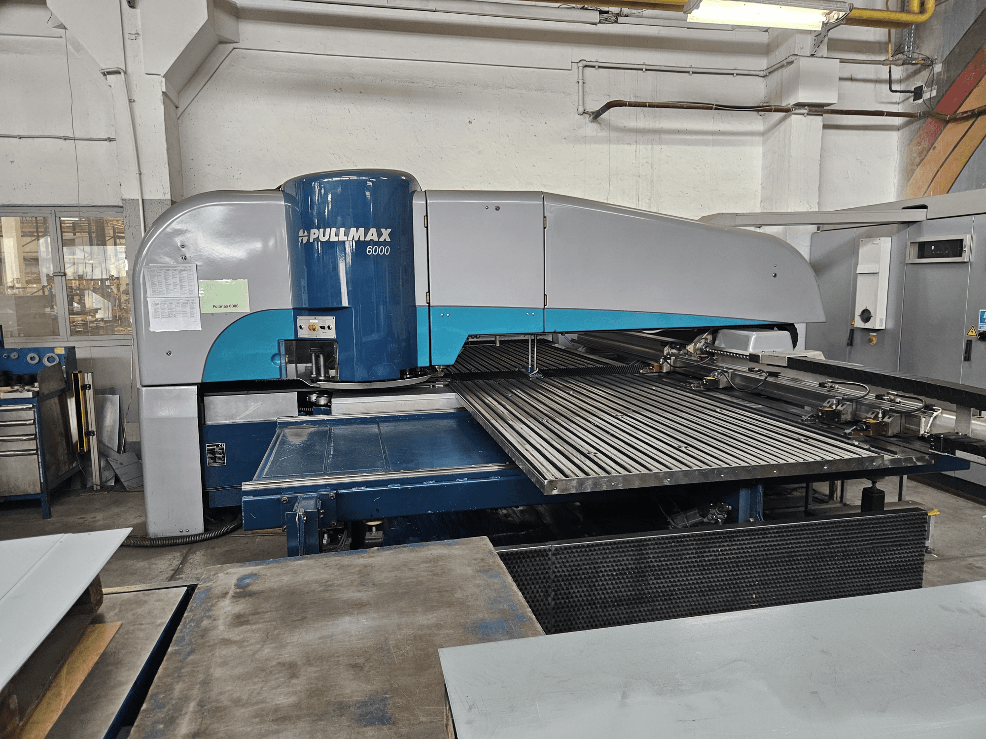 Vue avant de la poinçonneuse Pullmax 6000 CNC, montrant son grand plateau et sa structure métallique dans un atelier.