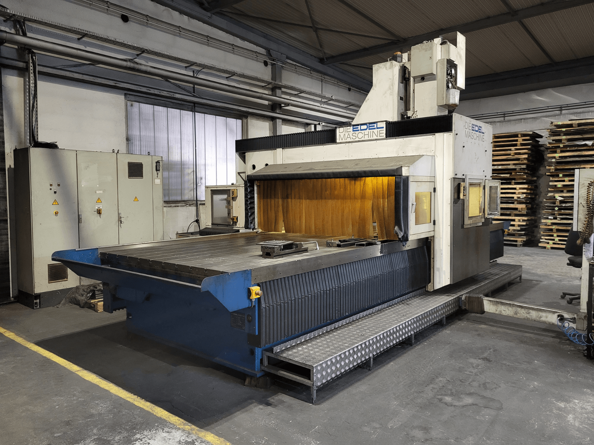 Fraiseuse à portique EDEL Koordimatic XL 4020, vue de face, montrant la grande table de travail et l'unité de commande dans un environnement industriel.