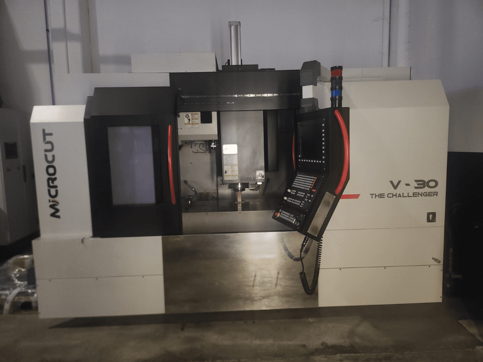 Microcut V-30 La machine CNC Challenger, vue de face, avec le panneau de commande, la zone de découpe et les éléments de design industriel.