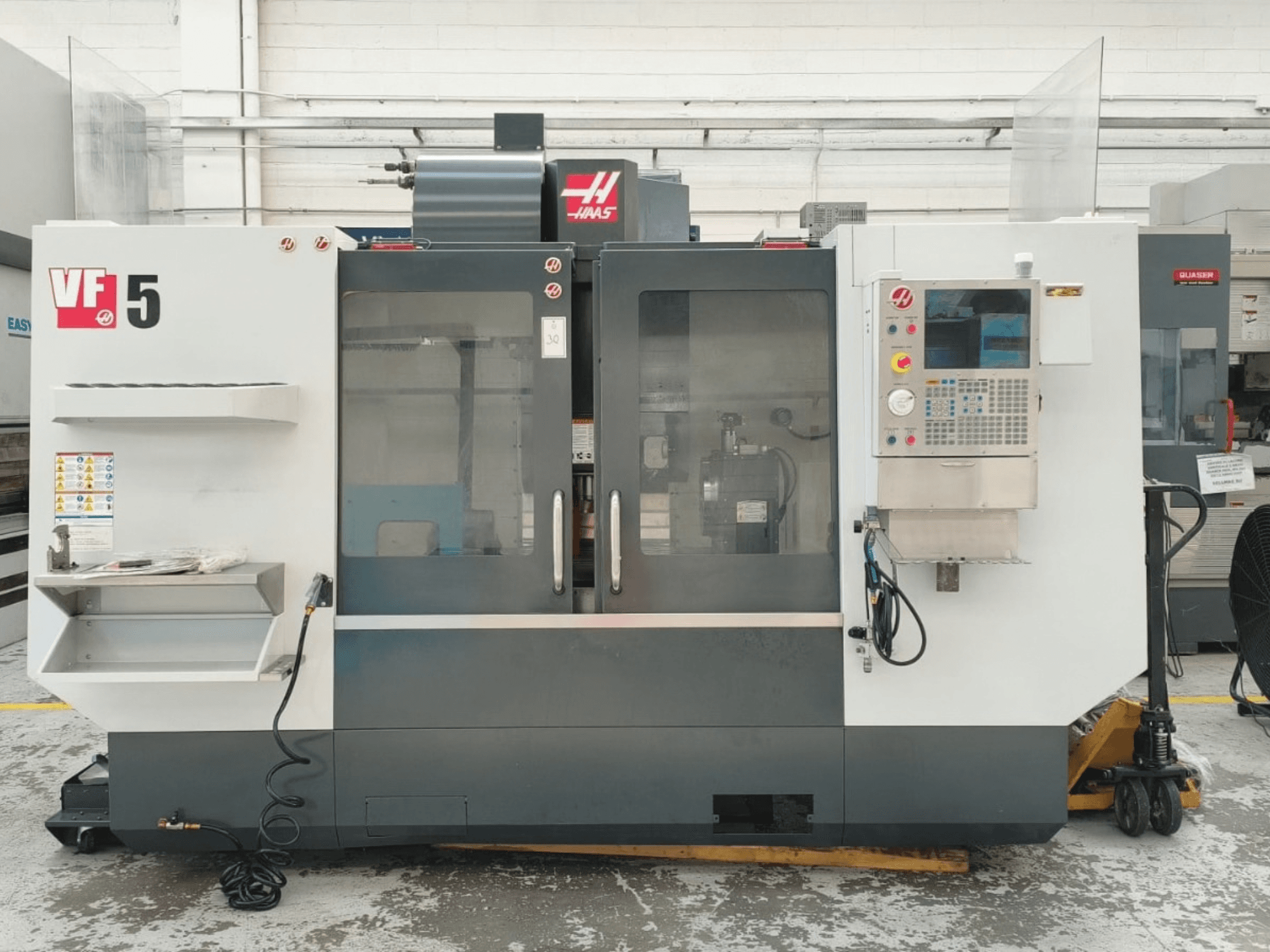 Vue de face du centre d'usinage vertical HAAS VF 5/40, avec son panneau de commande et ses portes vitrées.