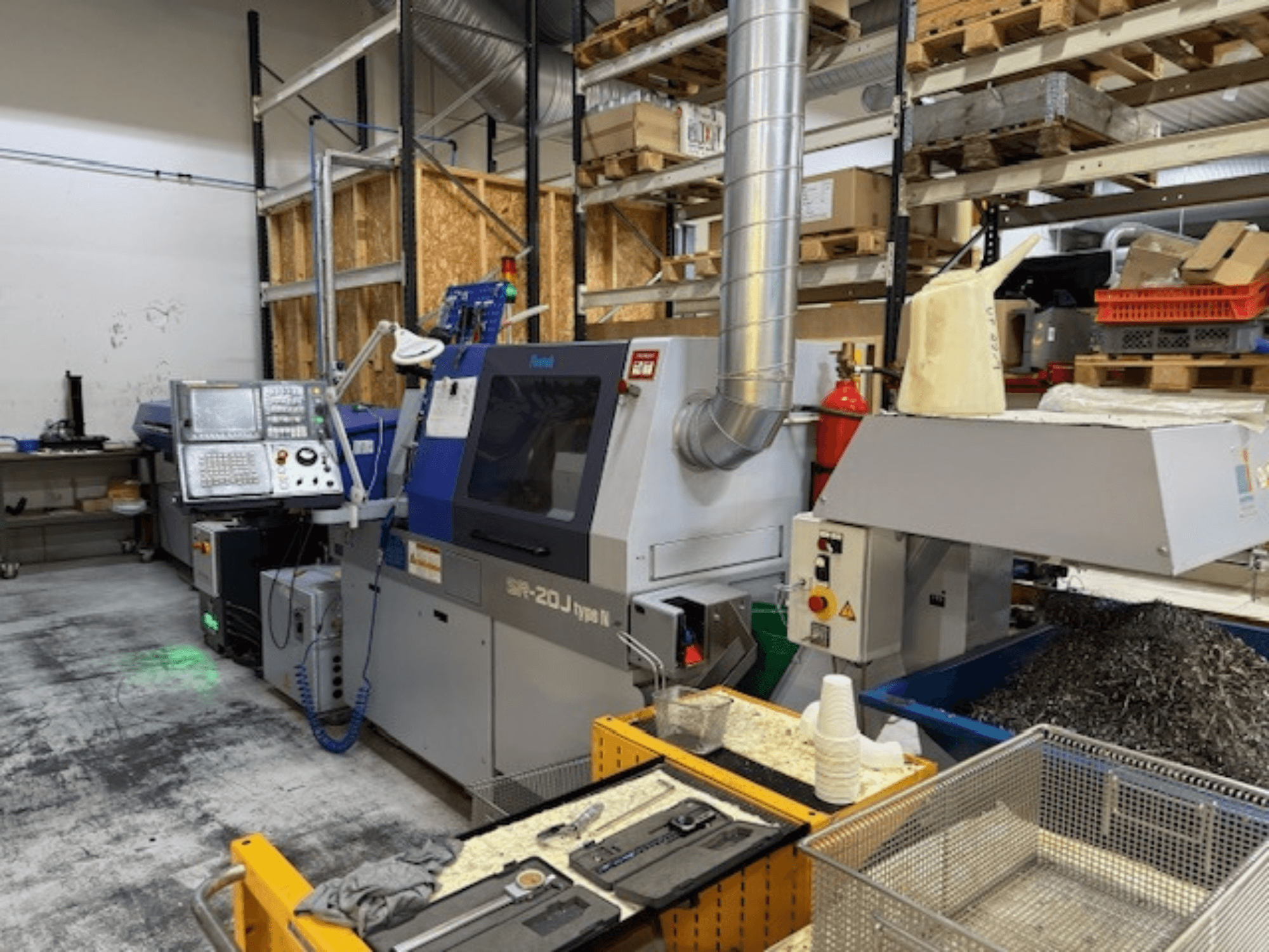 Vue de face d'un centre d'usinage Faroh SPR-20J type N avec panneau de commande, copeaux de métal et équipement de sécurité dans un atelier.