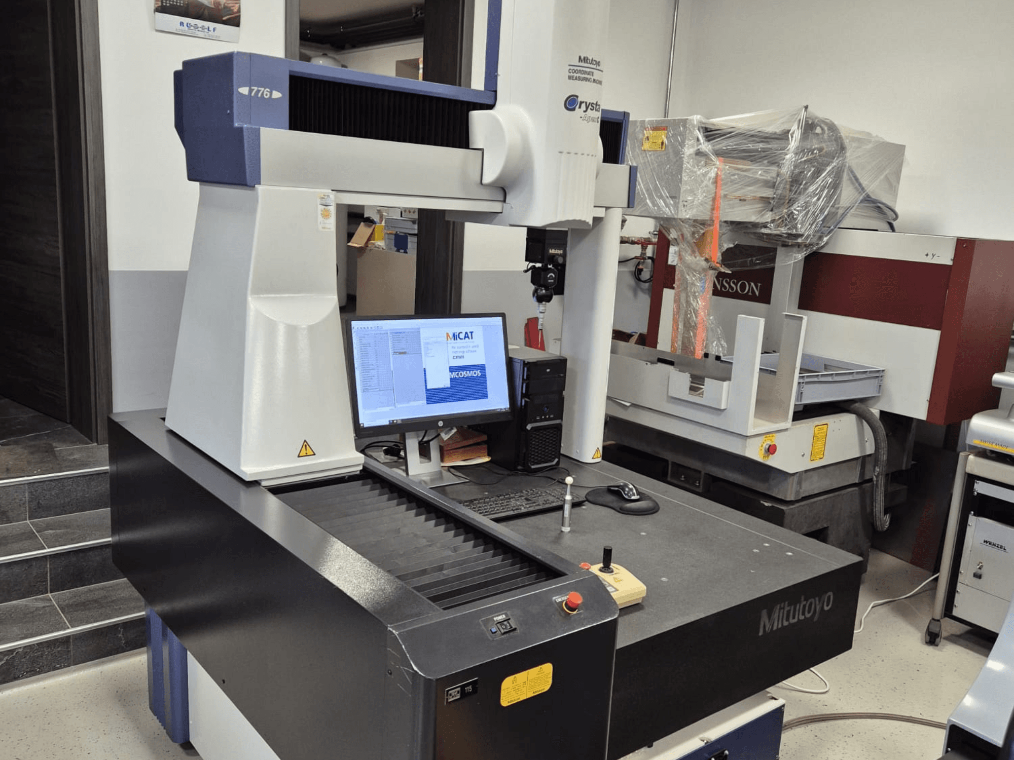 Machine à mesurer tridimensionnelle Mitutoyo modèle 776 vue de face, avec un moniteur affichant le logiciel de mesure et les commandes visibles.