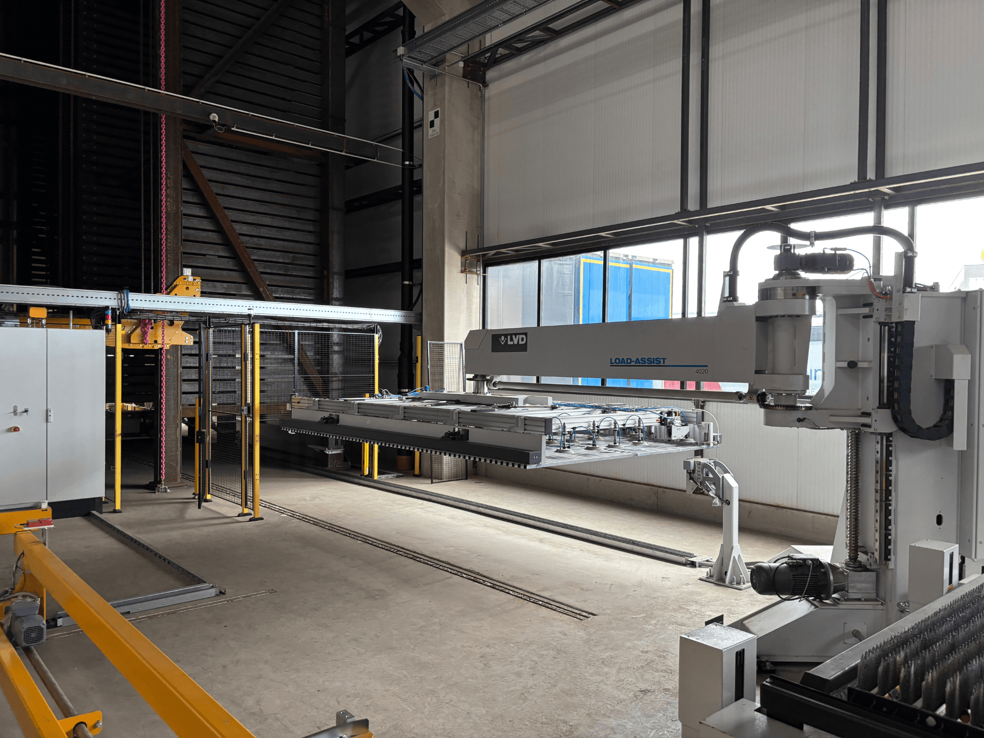L'équipement d'automatisation Load-Assist 4020 de LVD vu de face avec un bras robotisé et un système de chargement visible dans un grand espace de travail.