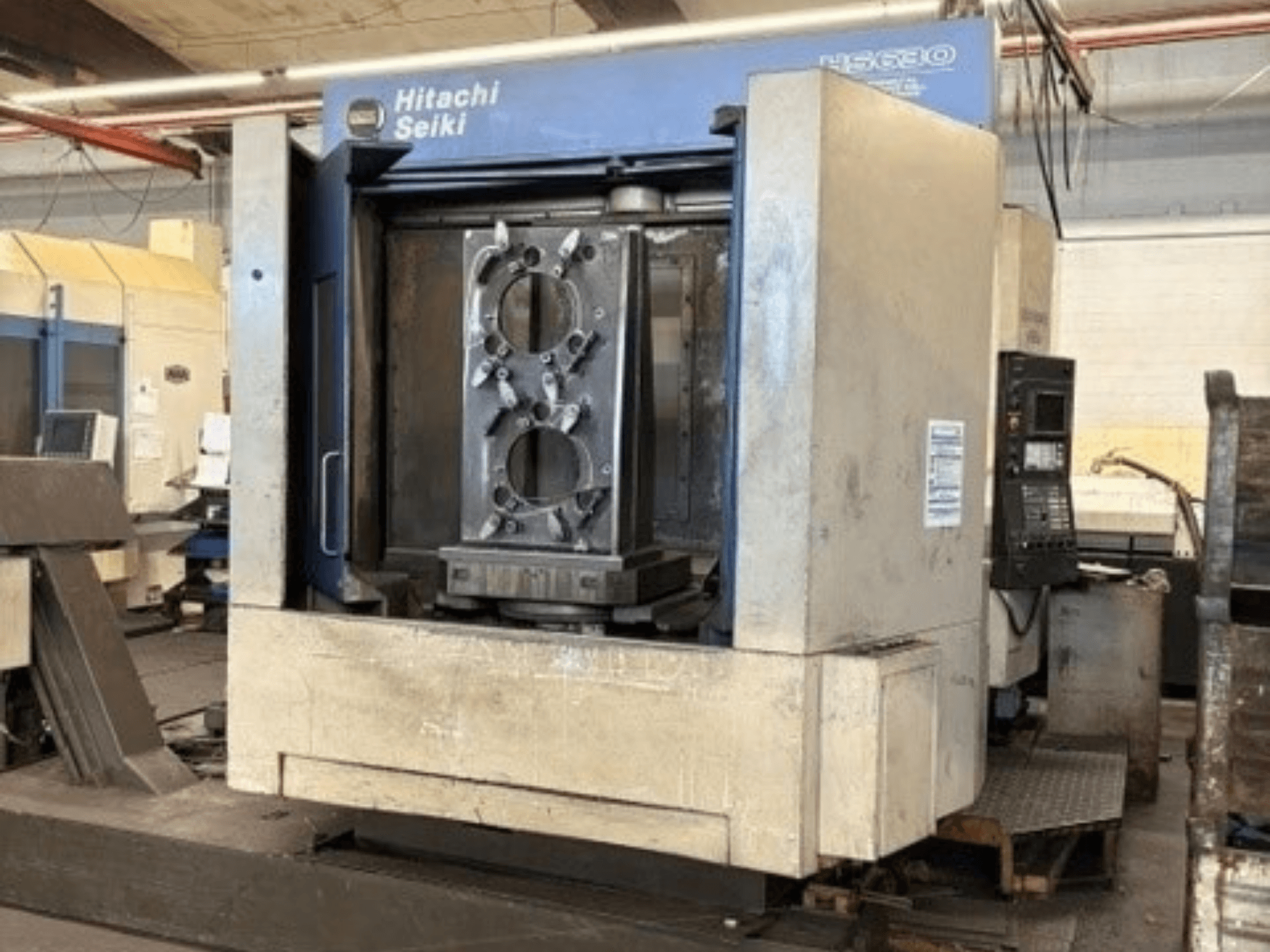 Centre d'usinage horizontal Hitachi Seiki HS630, vue de face montrant une pièce à usiner et le panneau de commande.