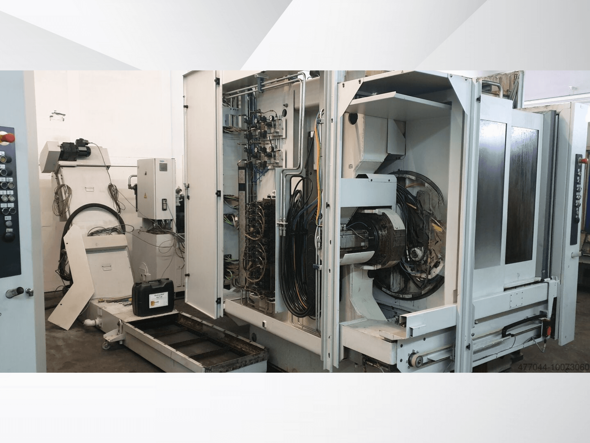 Machines industrielles dont le câblage, le panneau de commande et les composants mécaniques sont apparents ; vue latérale d'une machine complexe.