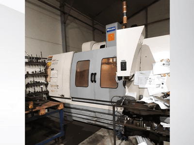 Centre d'usinage vertical VMC 1400 en vue latérale, avec panneau de commande, porte-outils et encombrement de l'espace de travail.