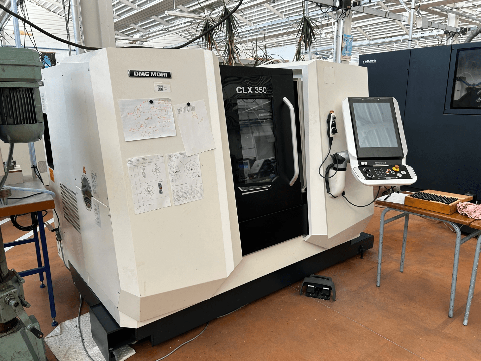 Tour horizontal DMG MORI CLX 350 V4, vue de face avec le panneau de commande et les documents techniques joints.