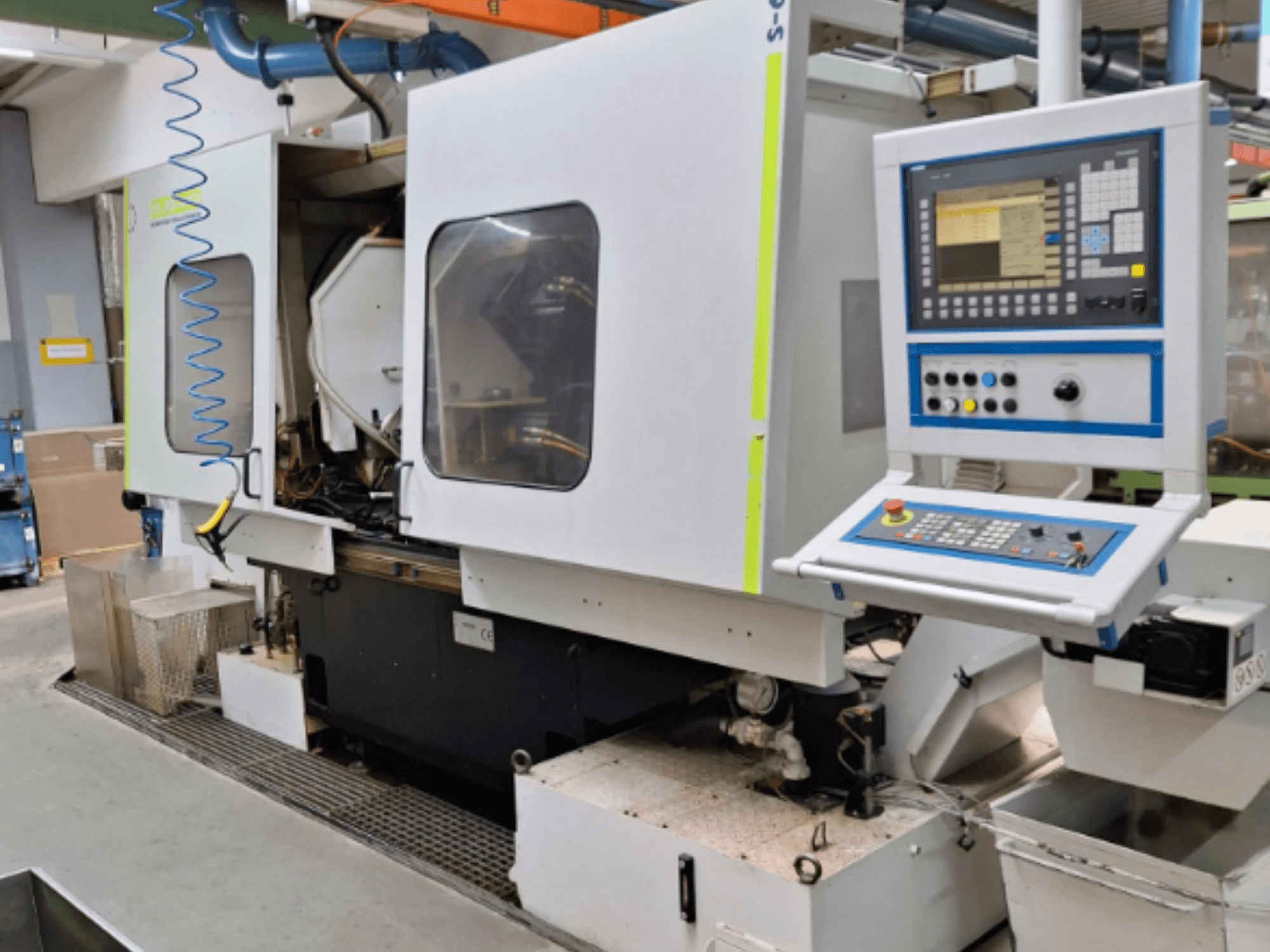 Fraiseuse industrielle avec panneau de commande, vue latérale, comportant deux chambres et des raccords de tuyauterie visibles.