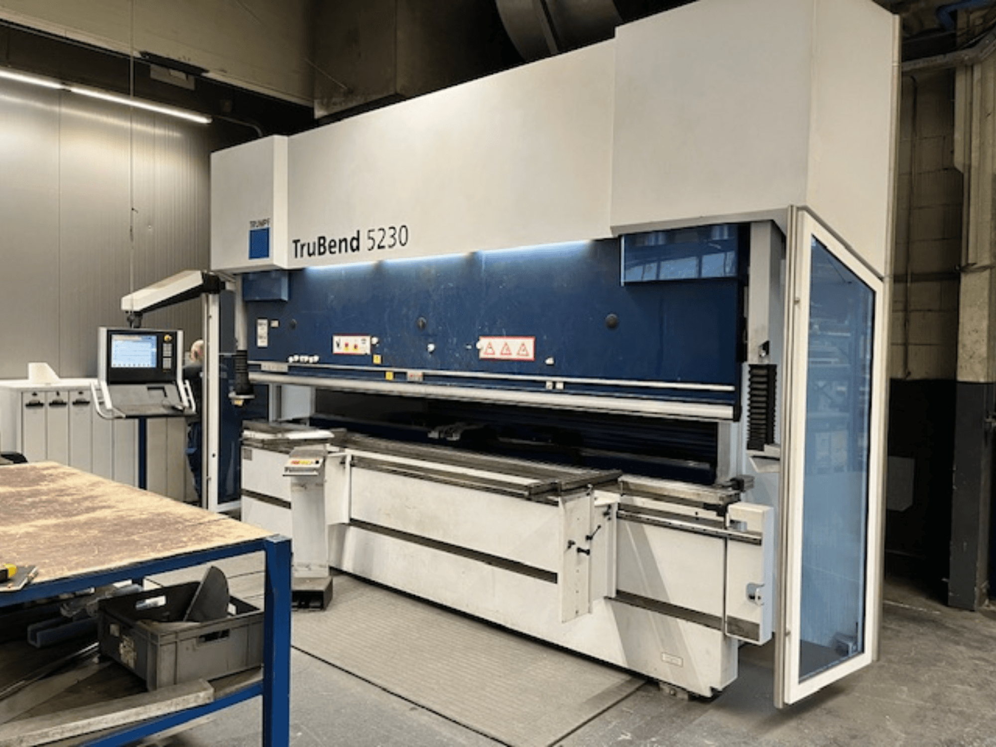 Machine à cintrer TruBend 5230 dans un environnement industriel ; vue de face montrant le panneau de commande, les dispositifs de sécurité et la table de travail.