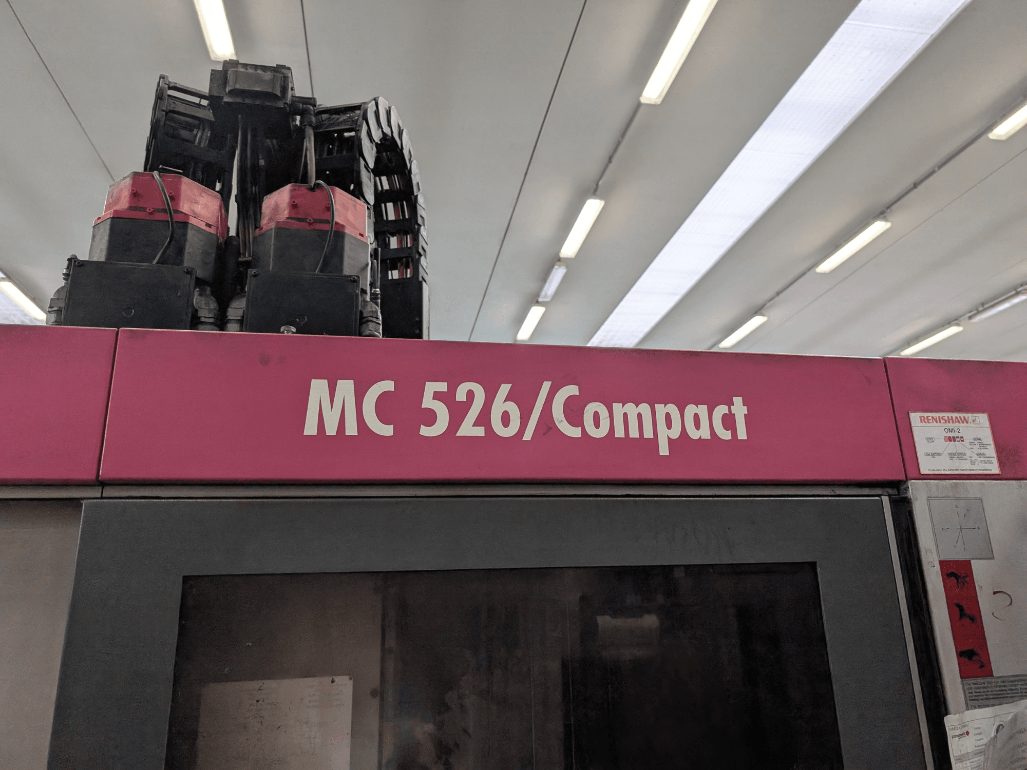 Machine MC 526/Compact rose avec deux moteurs et câbles, vue de dessus. Comprend l'étiquette Renishaw sur le côté.