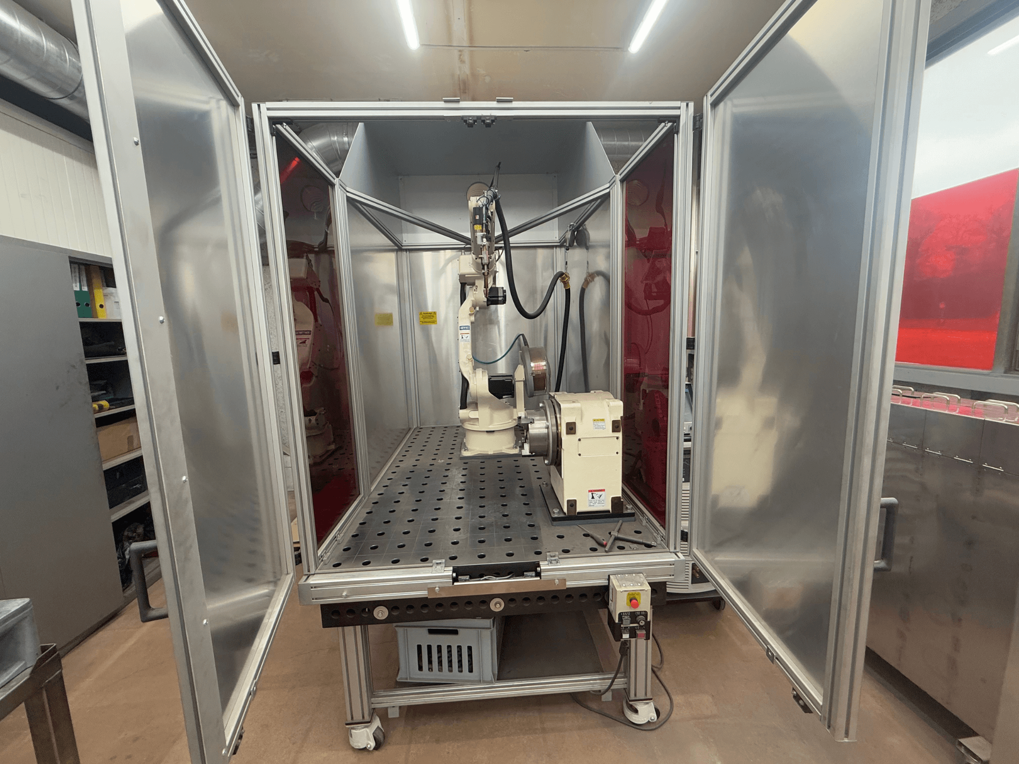 Robot de soudage OTC Daihen EASY ARC V02.04 dans un boîtier métallique, vu de face, présentant son bras articulé et son panneau de commande.