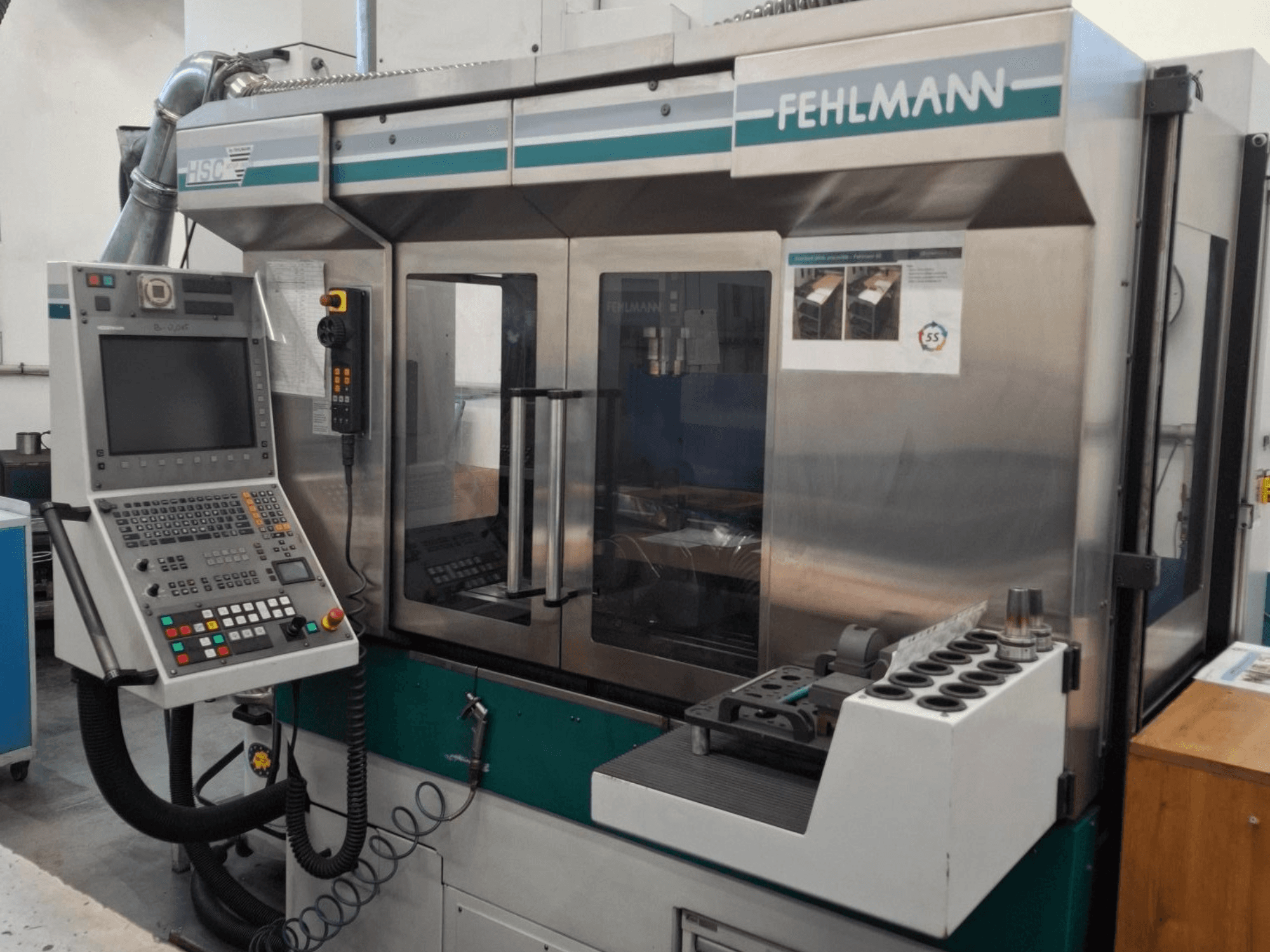 Machine CNC HSC 20 de Fehlmann, vue de face, comprenant le panneau de commande, le boîtier métallique et le porte-outil à fentes multiples.