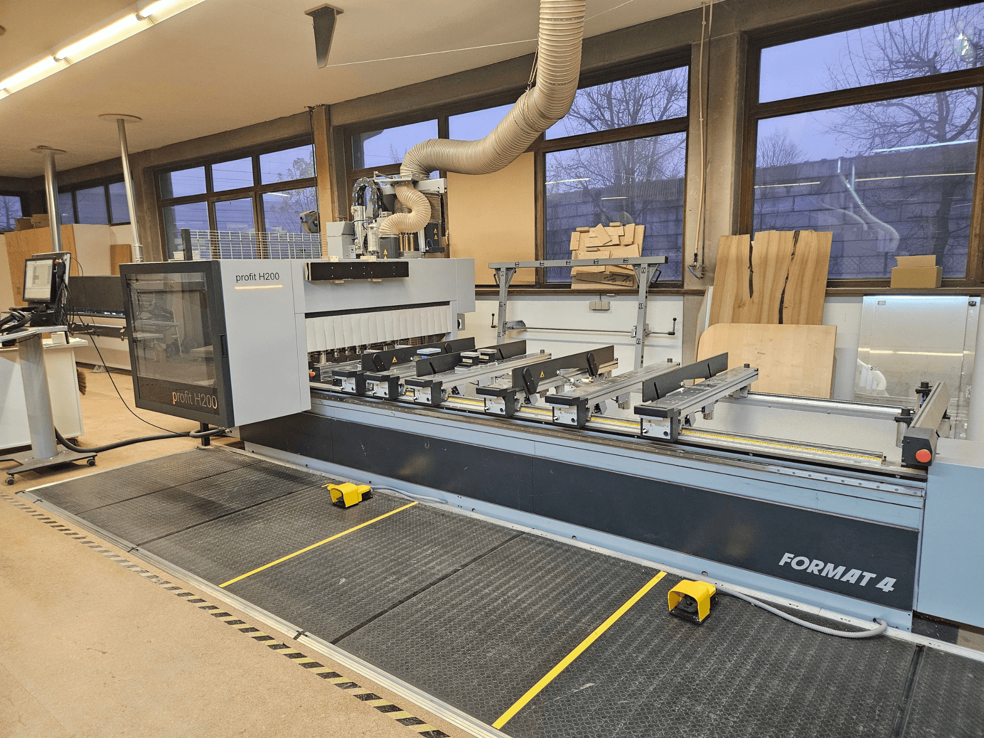 Format 4 profit Machine CNC H200, vue de face, avec le banc de coupe, le panneau de commande et le système d'extraction de la poussière visibles.