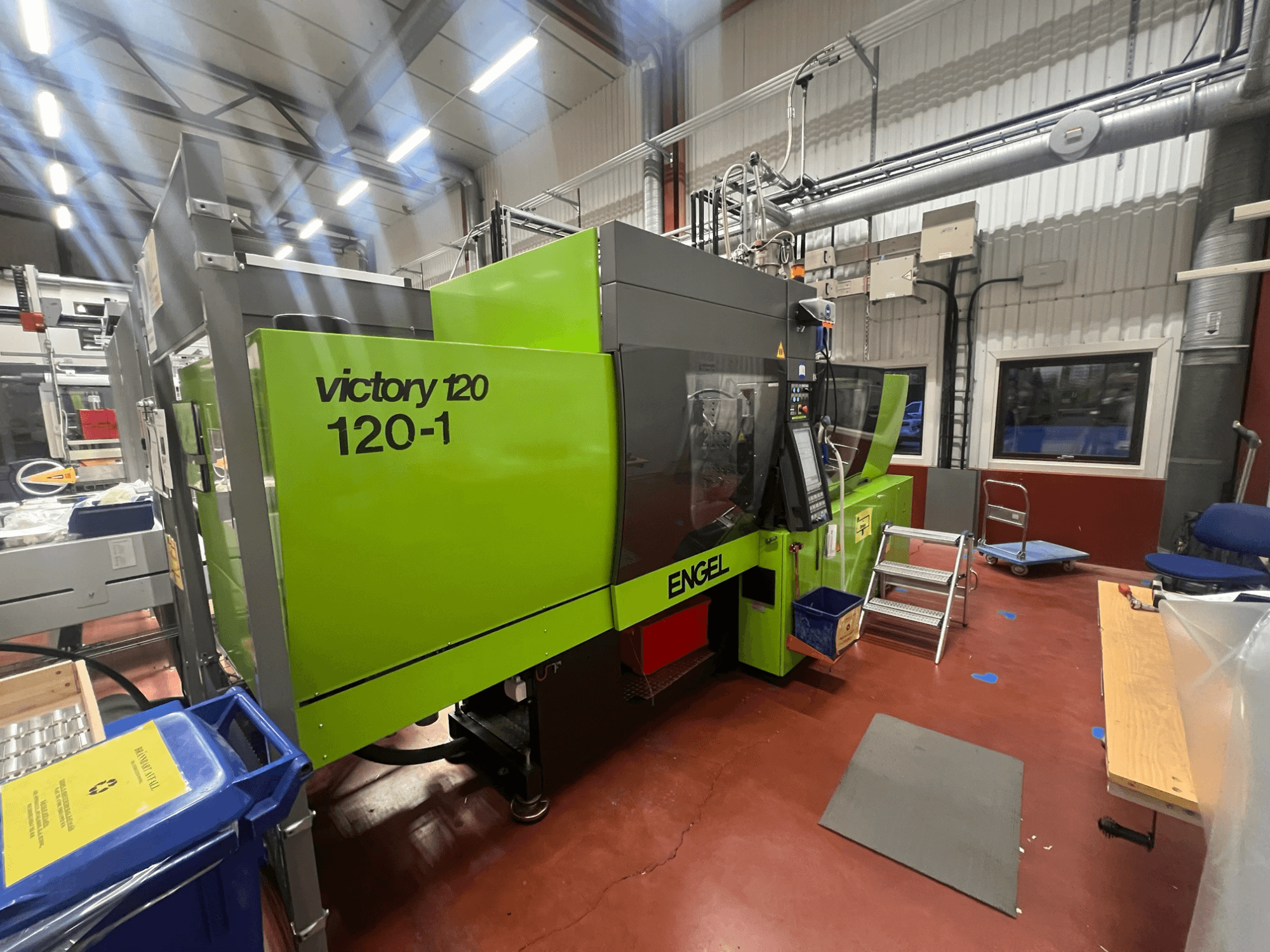 Machine de moulage par injection ENGEL Victory 120-1 verte, vue de face, avec panneau de commande et marches, dans un environnement industriel.