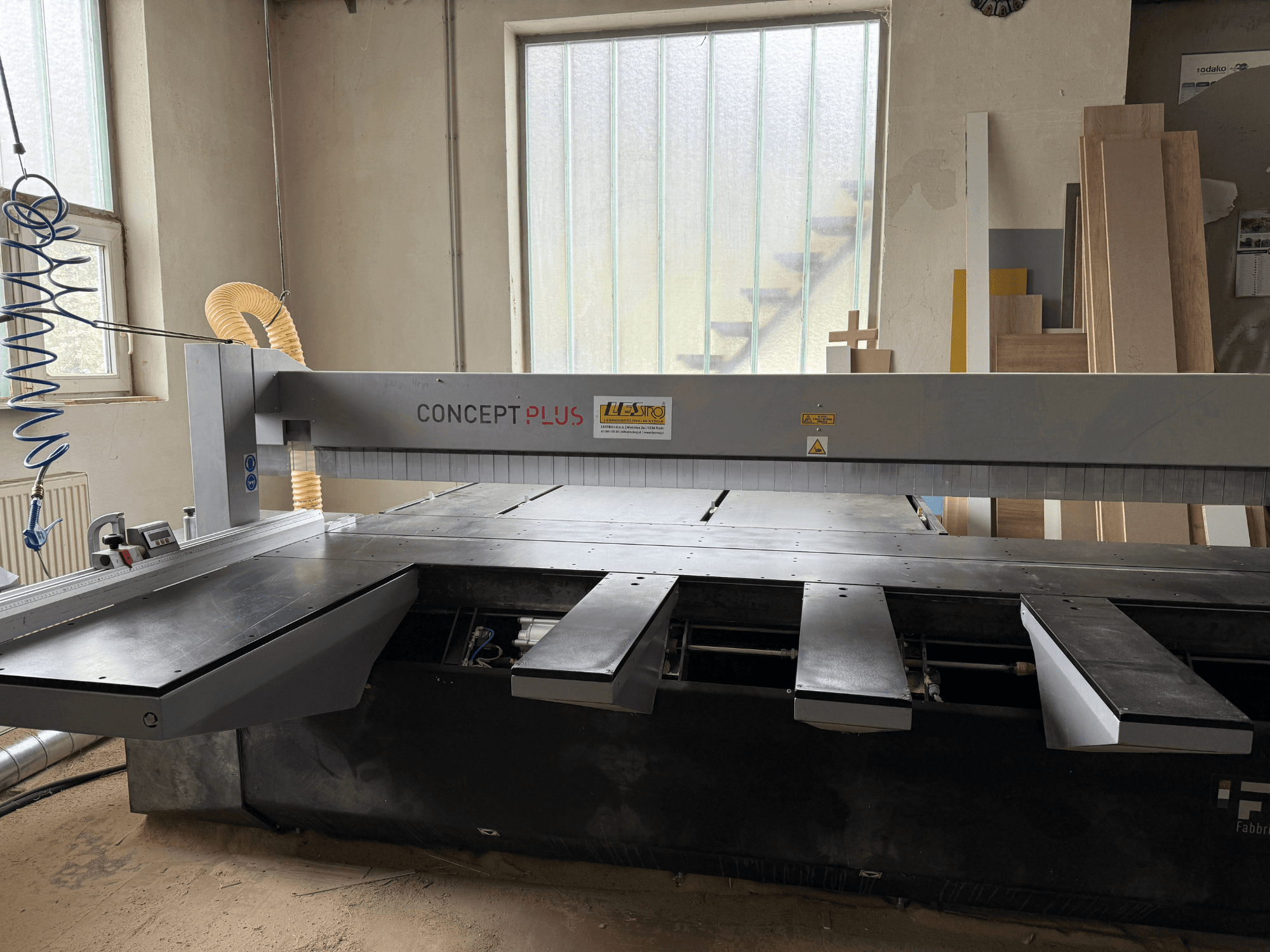 Scie à panneaux FIMAL Concept 350 dans un atelier ; vue de face avec table extensible et panneaux de bois en arrière-plan.