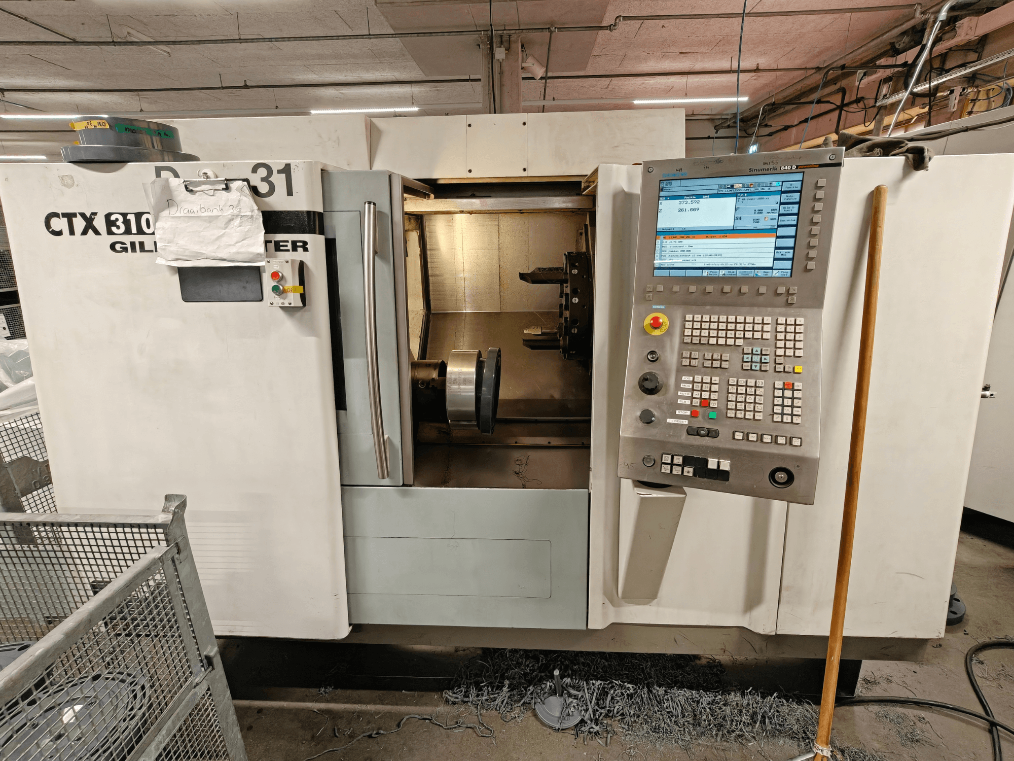 Tour horizontal Gildemeister CTX 310, vue de face avec panneau de commande, montrant les outils et l'espace de travail à l'intérieur.