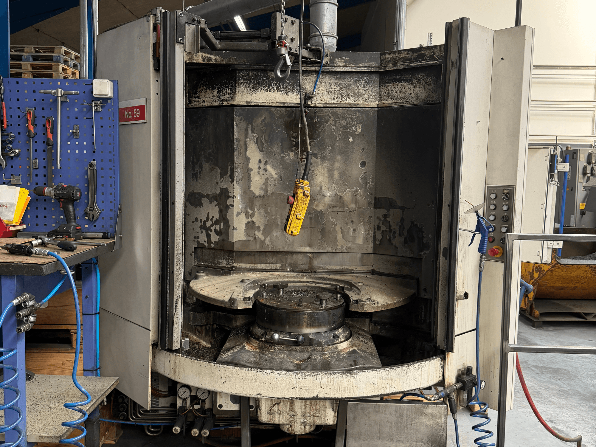 Centre d'usinage horizontal HELLER MC 16 vue de face, révélant une table de travail et un panneau de commande vides, dans un atelier.