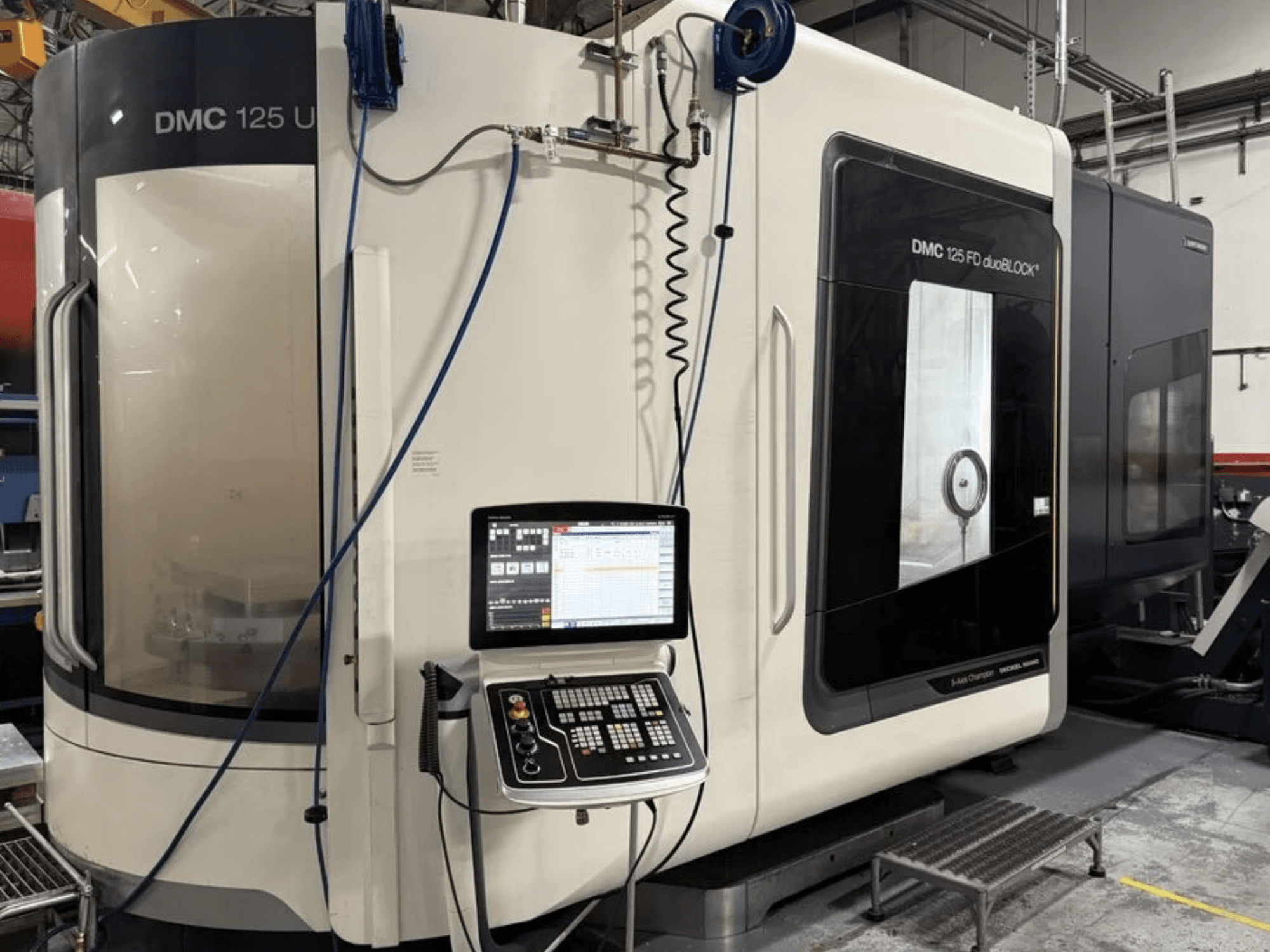 Centre d'usinage universel DMG MORI DMC 125 U duoBLOCK, vue de face avec le panneau de commande et les surfaces réfléchissantes.