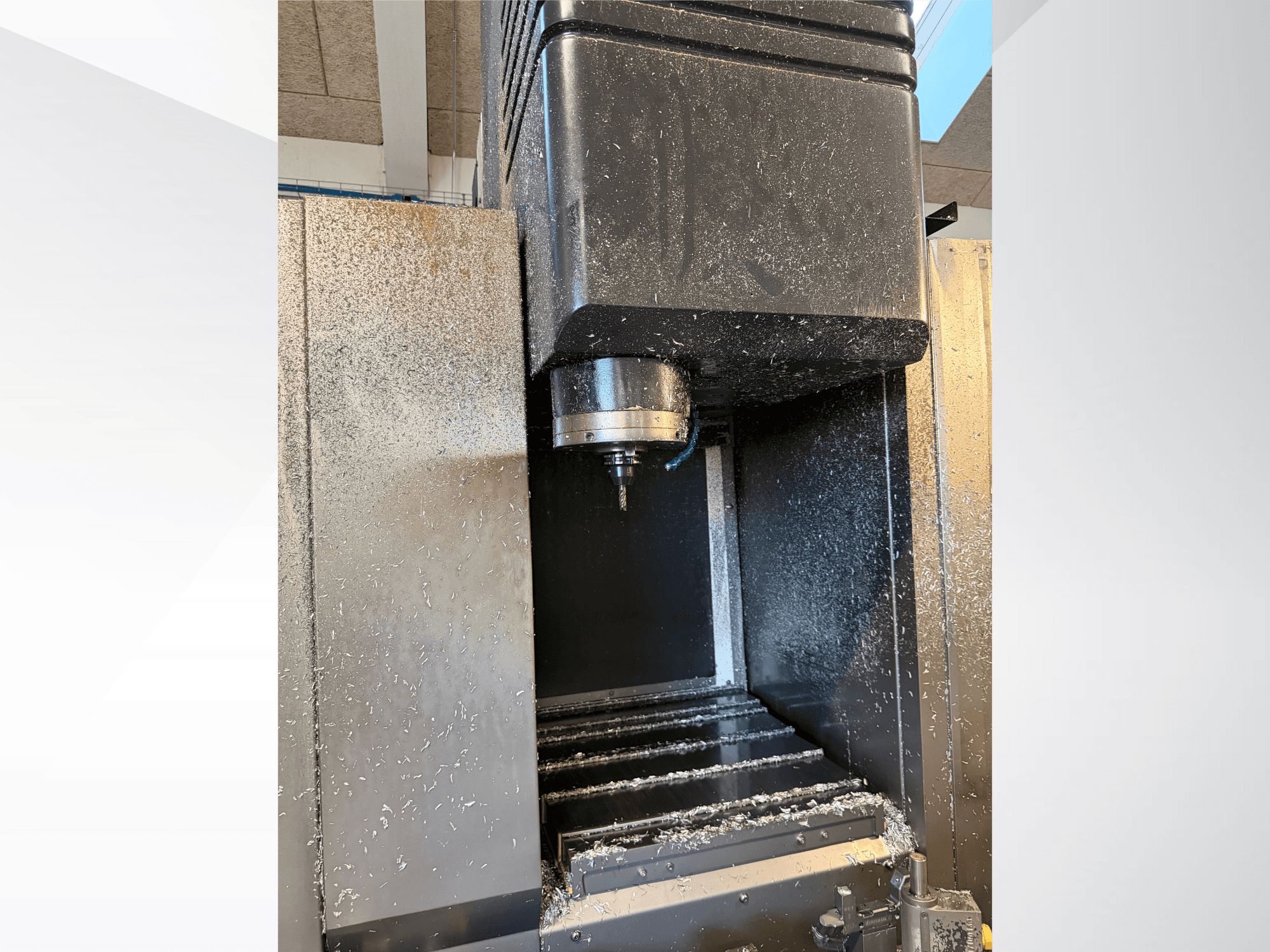 Centre d'usinage vertical Mazak VTC 300C II, vue de face, montrant la broche et les copeaux issus du processus d'usinage.