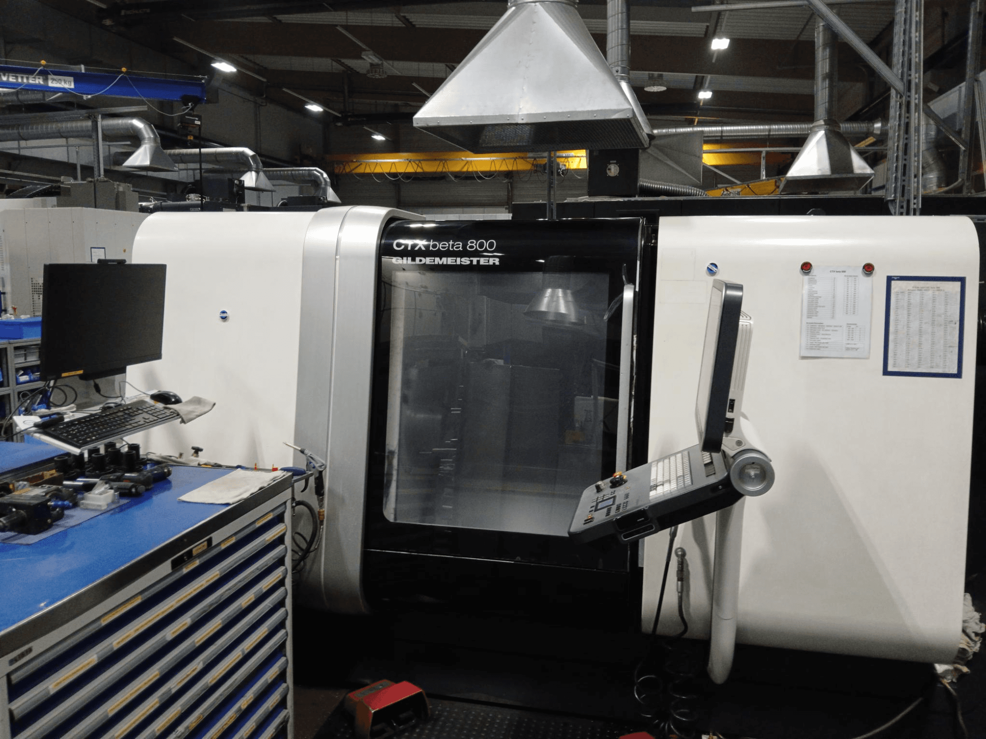 Tour horizontal DMG CTX beta 800, vue de face avec panneau de commande et moniteur à côté d'un poste de travail.