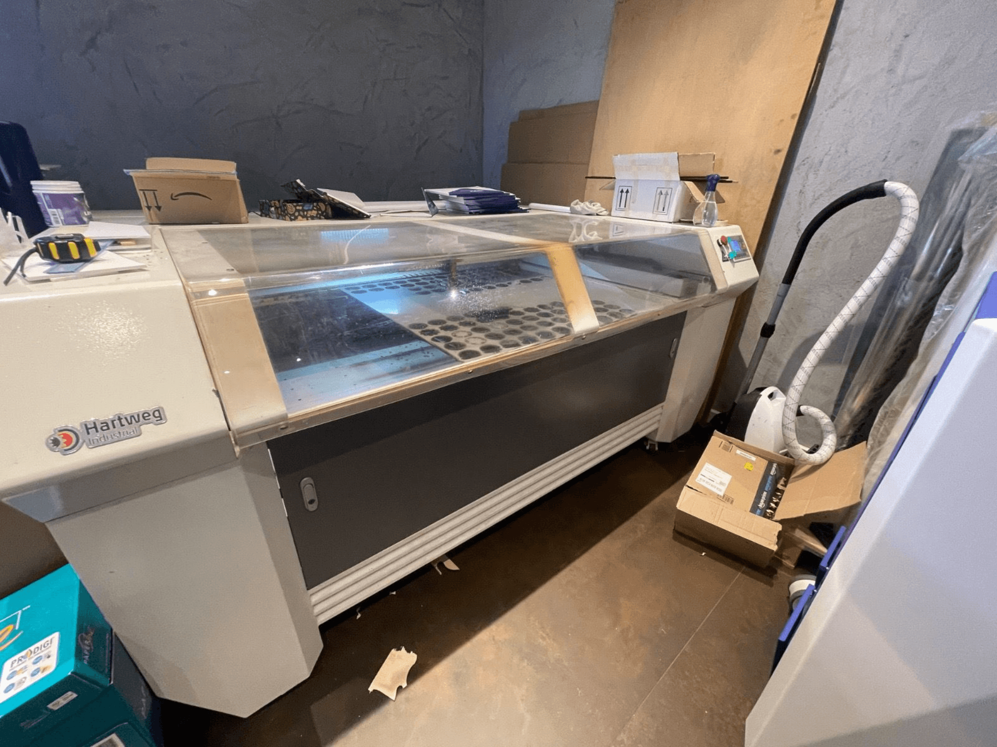 Machine de découpe laser CO2 Bodor CL-1610XUF en vue latérale, montrant la zone de travail avec les fentes pour les matériaux et le panneau de commande.