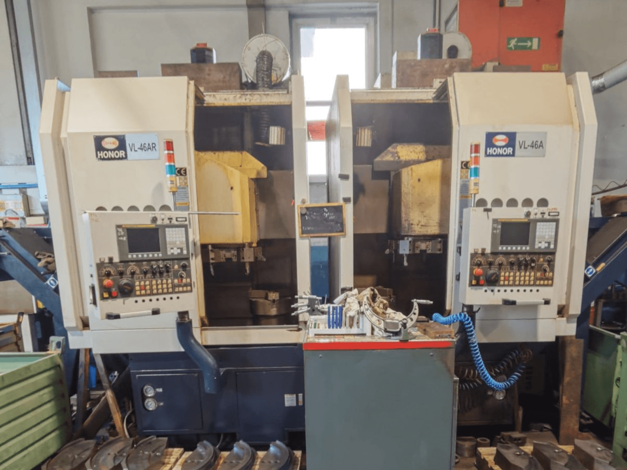 Tour vertical HONOR SEIKI VL 46 AR à deux postes de travail, vue de face montrant les panneaux de commande et les outils.