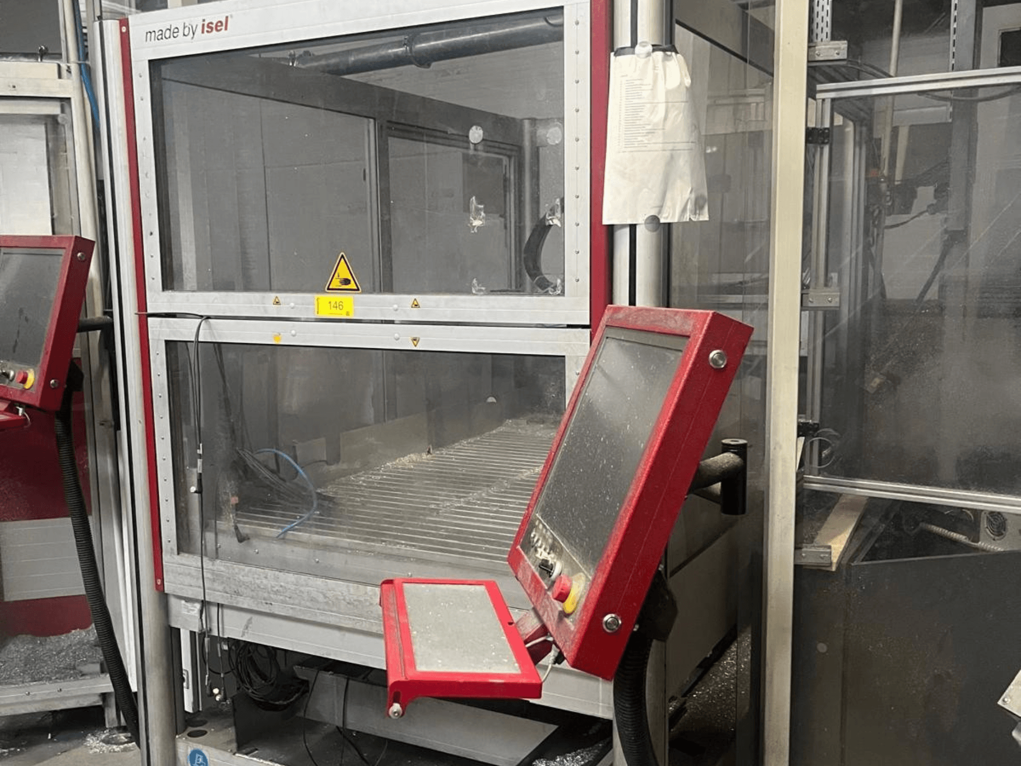 Centre d'usinage vertical ISEL FLATCOM M 30, vue de face montrant le panneau de commande, la zone de travail et les dispositifs de sécurité.