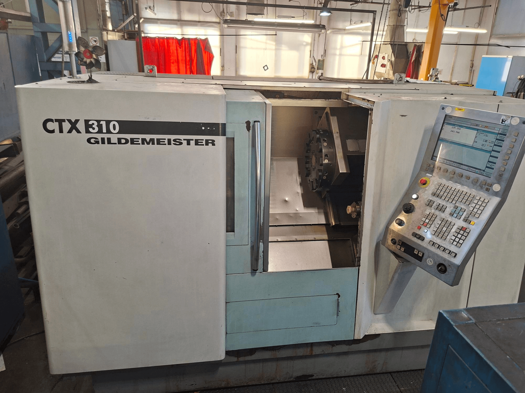Tour horizontal DMG CTX 310, vue de face, avec panneau de commande et accès ouvert à la zone de travail.