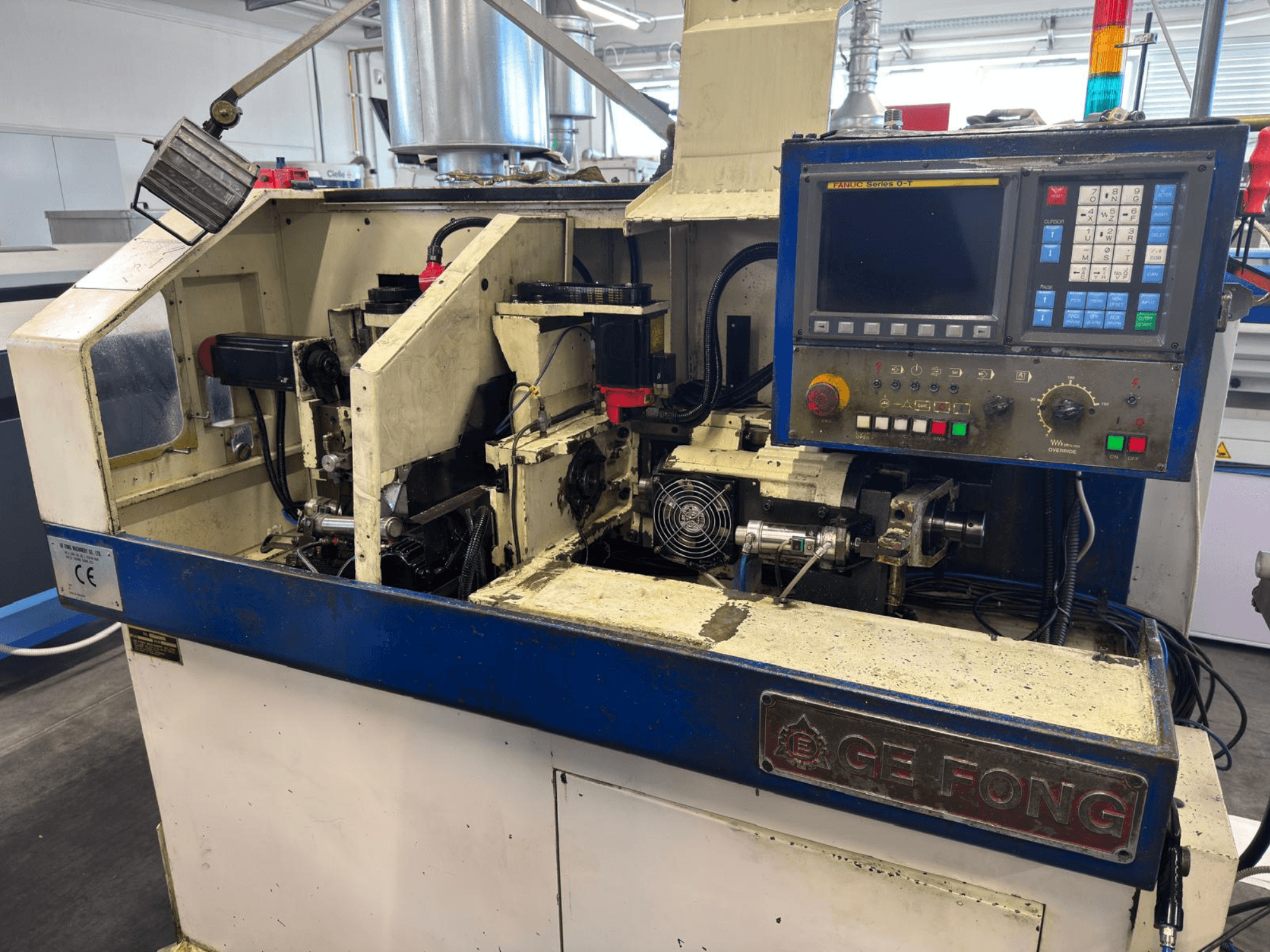 Machine industrielle GE FONG vue de face, montrant les composants internes, le panneau de commande et les pièces opérationnelles.