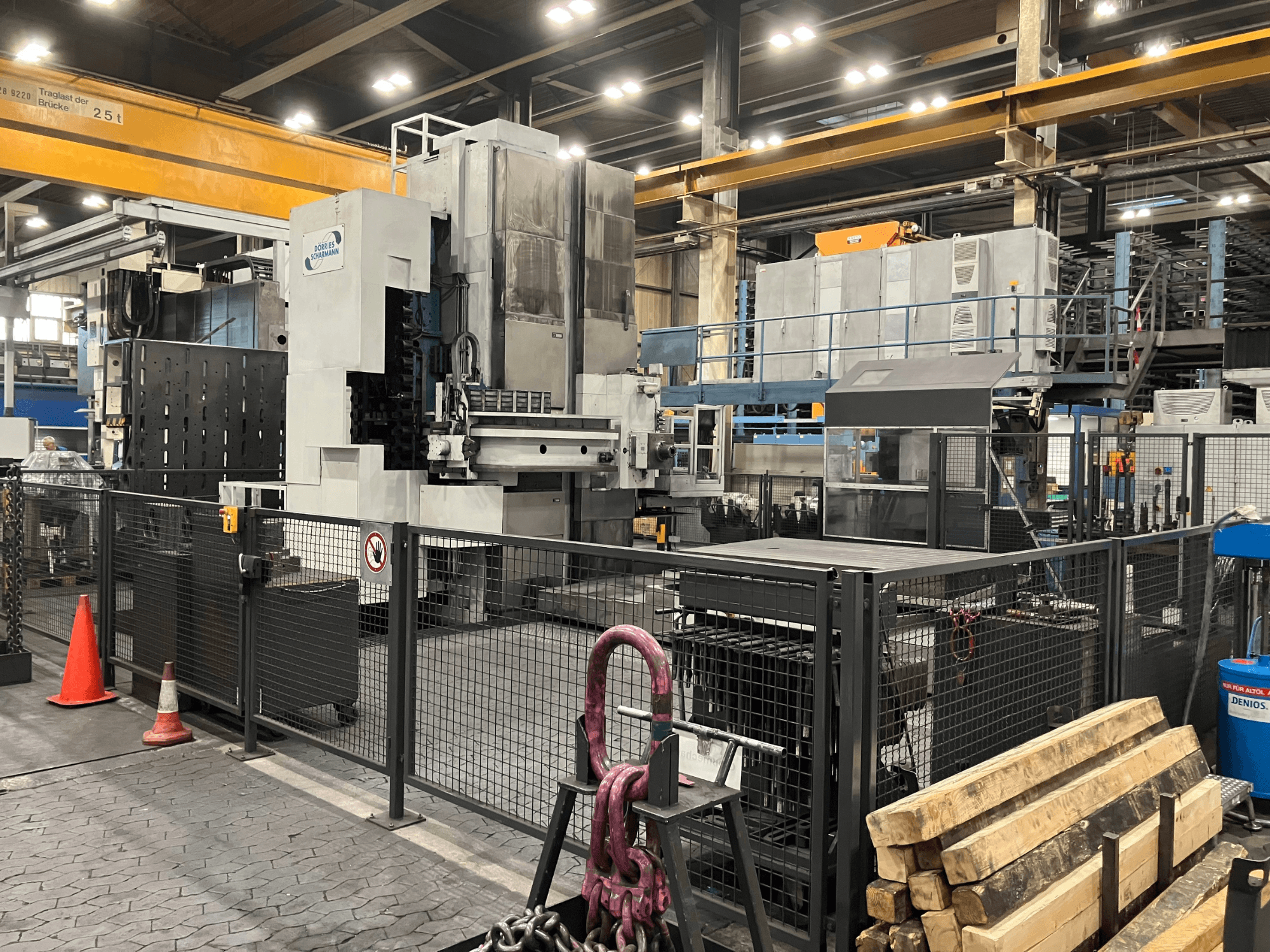 Aléseuse DÖRRIES SCHARMANN Heavycut 1.2 TDV4 dans son environnement d'usine, vue de profil avec les barrières de sécurité et les outils à proximité.