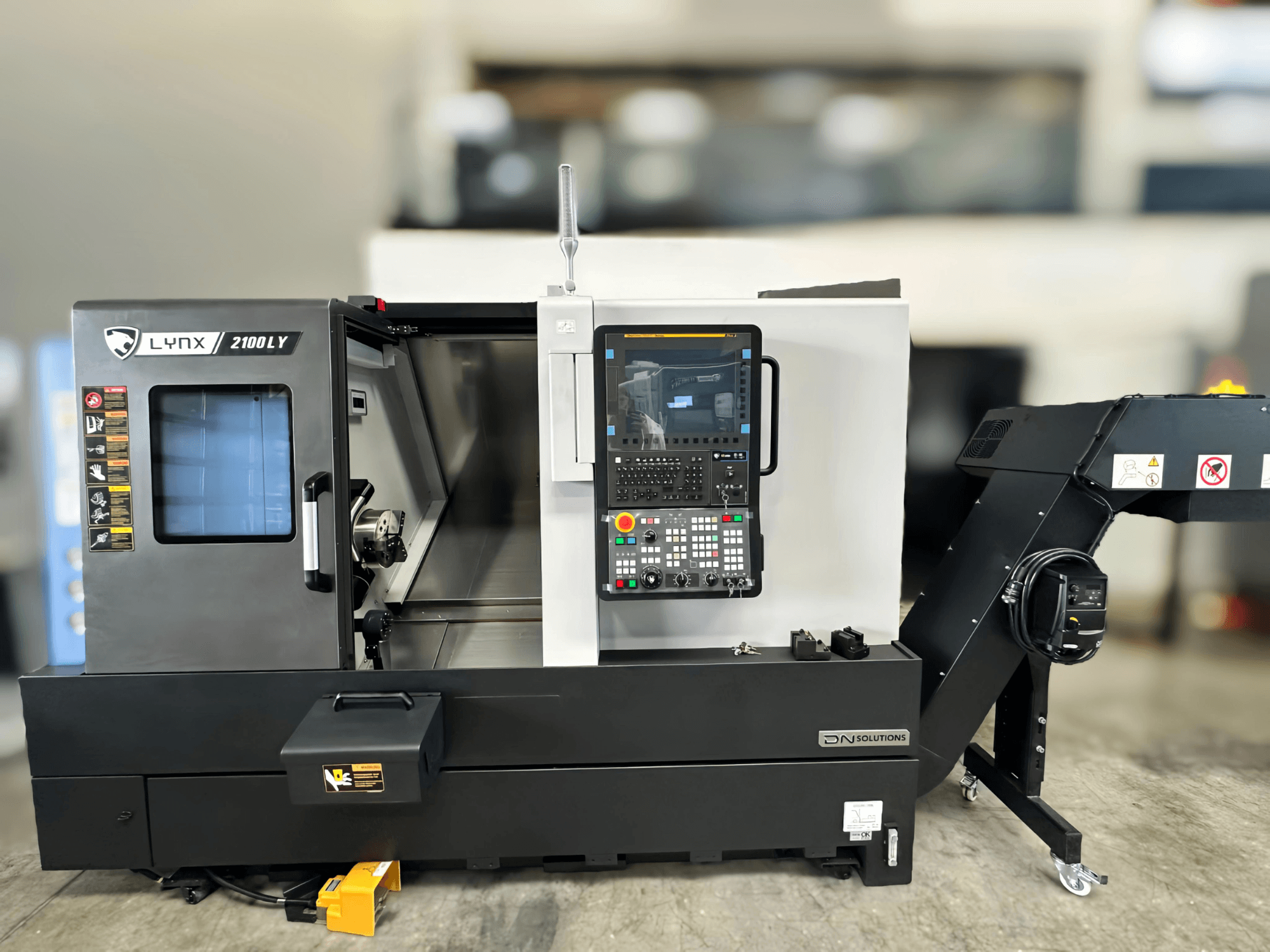 Tour horizontal DN SOLUTIONS LYNX 2100LYB, vue de face, avec panneau de commande et porte ouverte révélant l'intérieur.