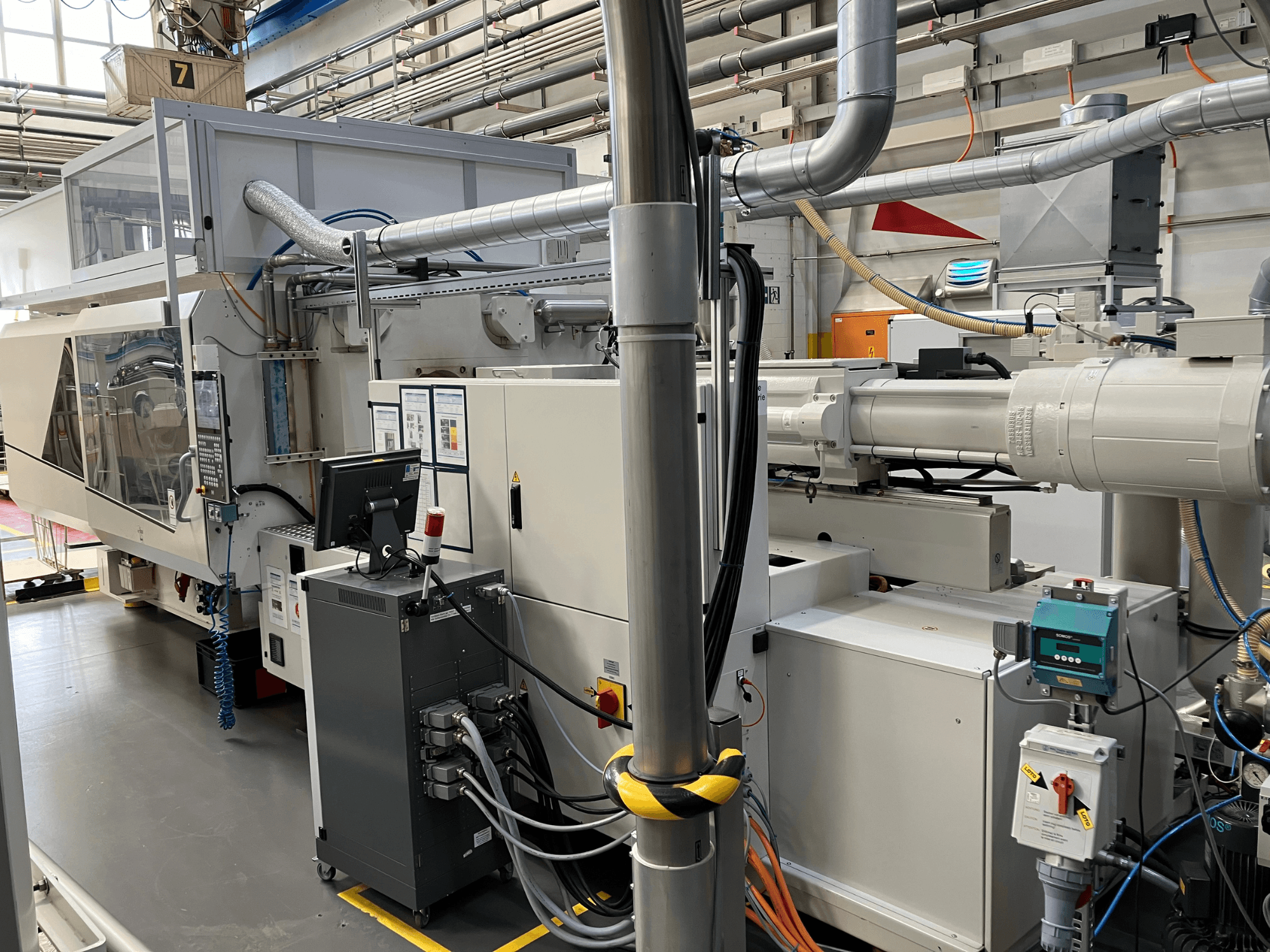 Machine industrielle avec panneau de commande, vue de face, comportant des tuyaux, des composants électriques et des dispositifs de sécurité.