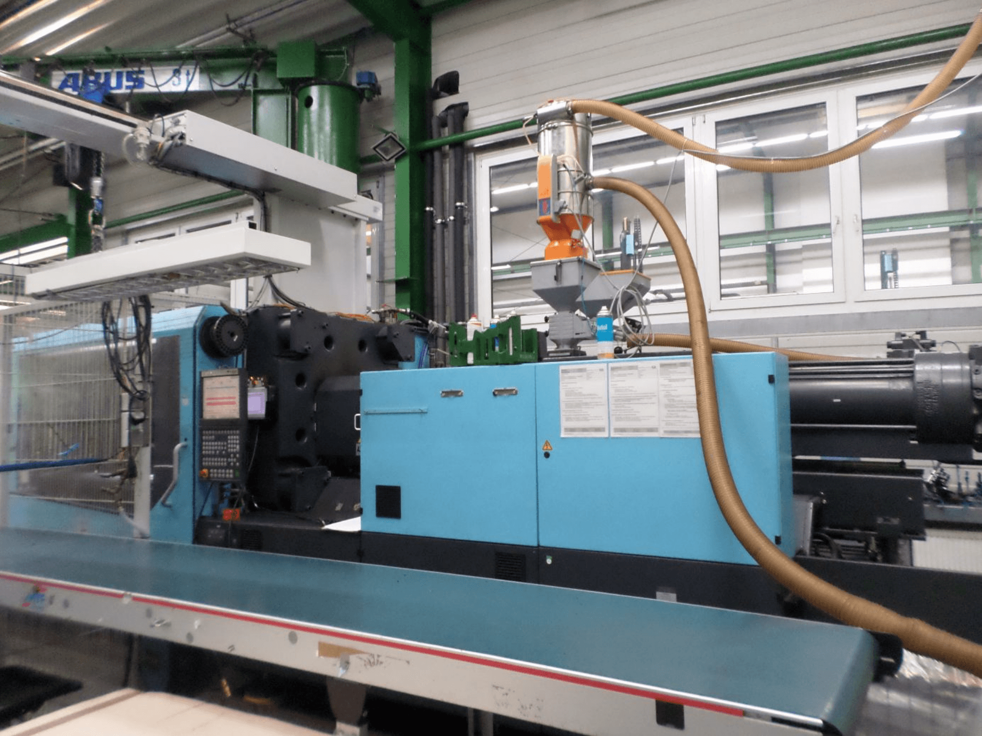 Vue de face d'une presse à injection hydraulique DEMAG D 420, montrant le tableau de commande, la trémie et les composants hydrauliques.