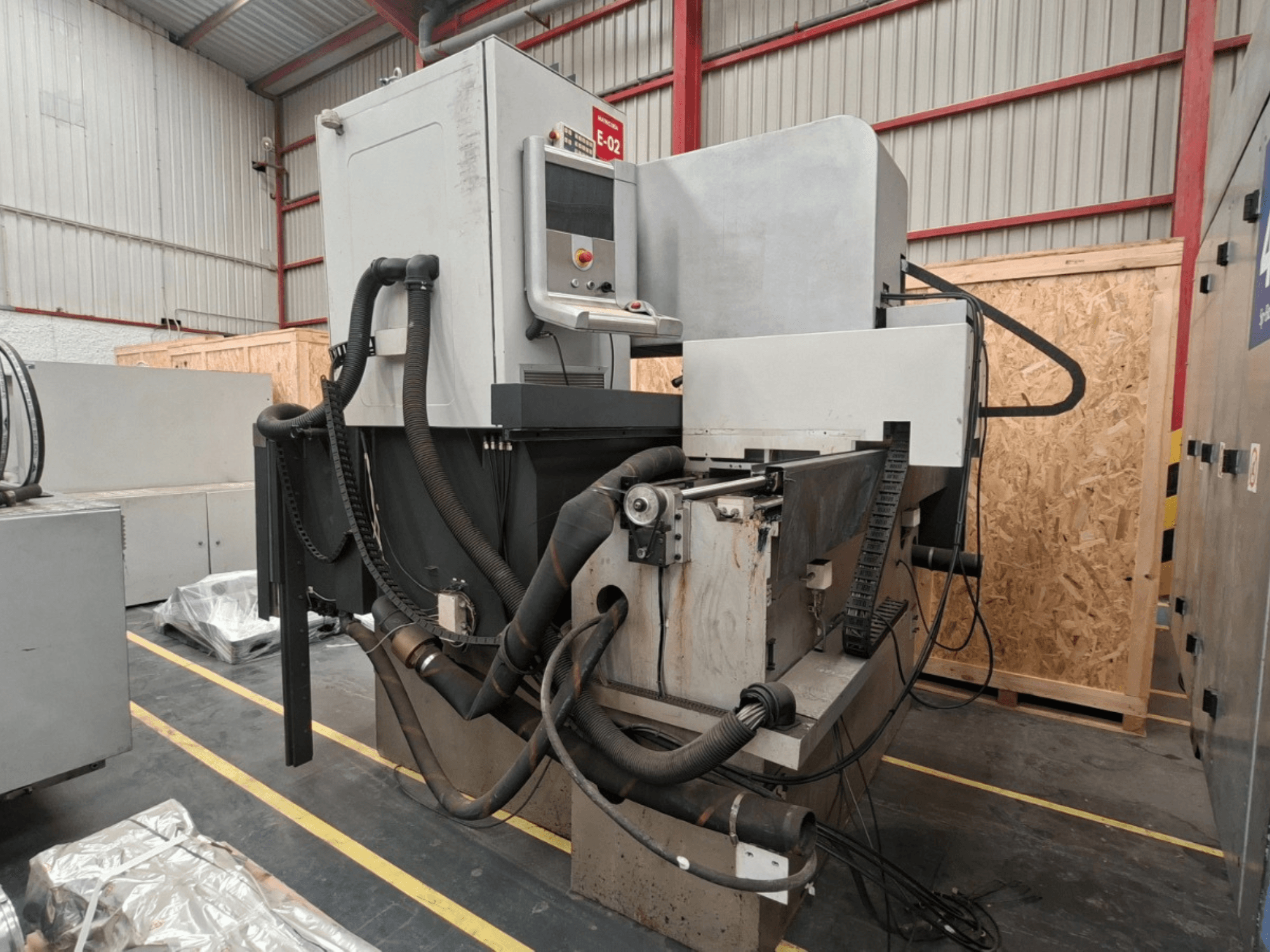 Machine d'électroérosion par enfonçage ONA NX7, vue de profil montrant le panneau de commande, les flexibles et la zone d'usinage dans un atelier.