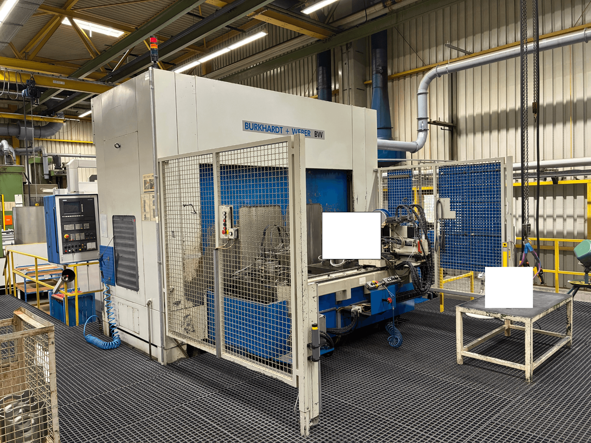 Centre d'usinage Burkhardt + Weber BW, vue de face, doté d'un panneau de commande et d'une enceinte de sécurité, situé dans un environnement industriel.