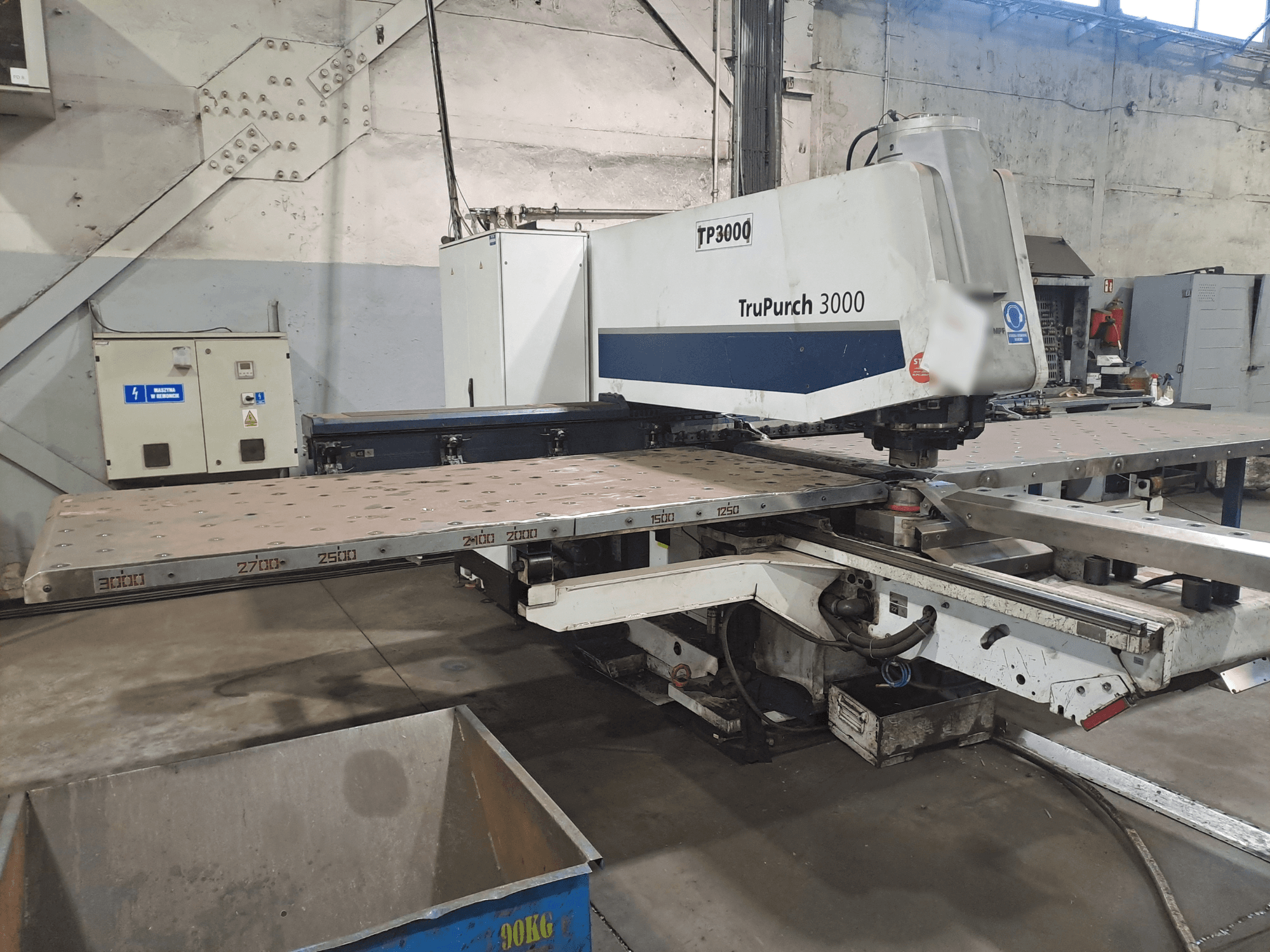 Machine CNC TruPunch 3000 présentée de face, avec une grande plaque métallique et des marquages de mesure, dans un environnement industriel.