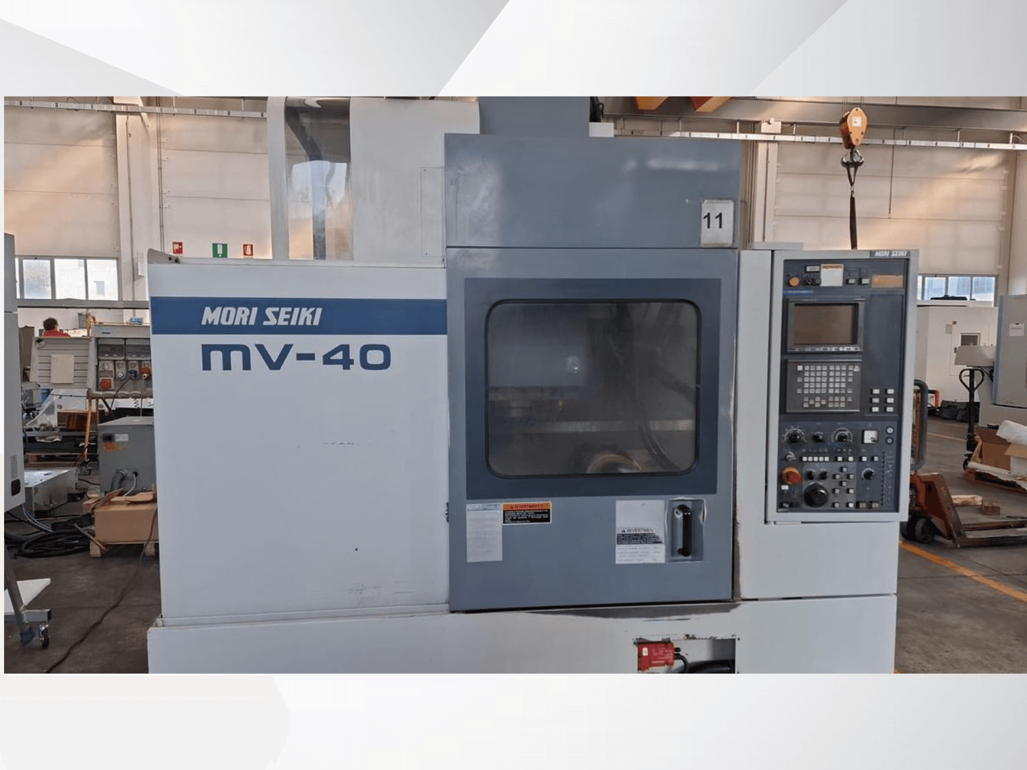 Centre d'usinage vertical MORI SEIKI MV-40, vue de face montrant le panneau de commande et la fenêtre, dans un atelier.