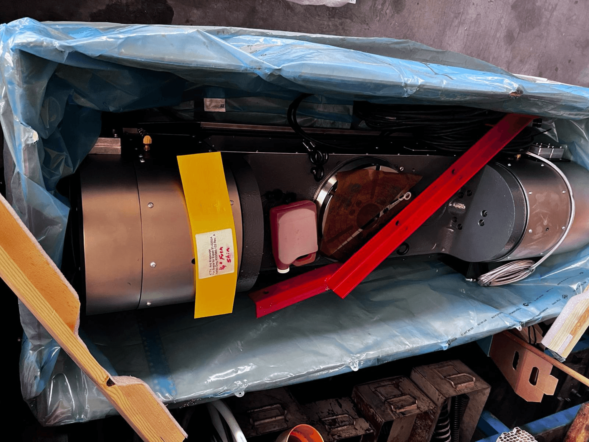 Le moteur, partiellement visible dans l'emballage, présente un extérieur argenté, des jauges colorées et un support rouge.