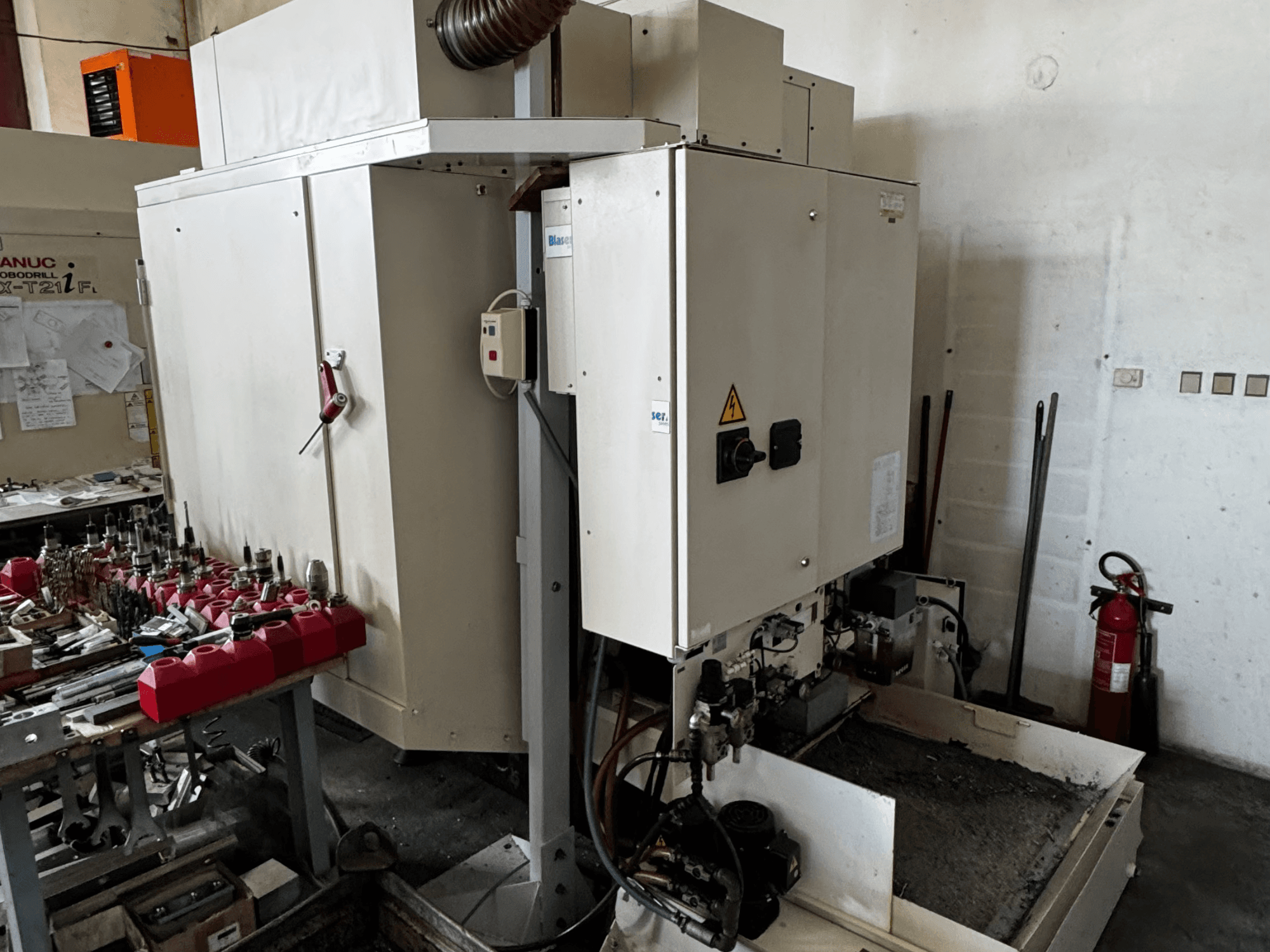 Centre d'usinage vertical FANUC Robodrill alpha-T21iFL, vue latérale montrant le panneau de commande, les outils et l'espace de travail.