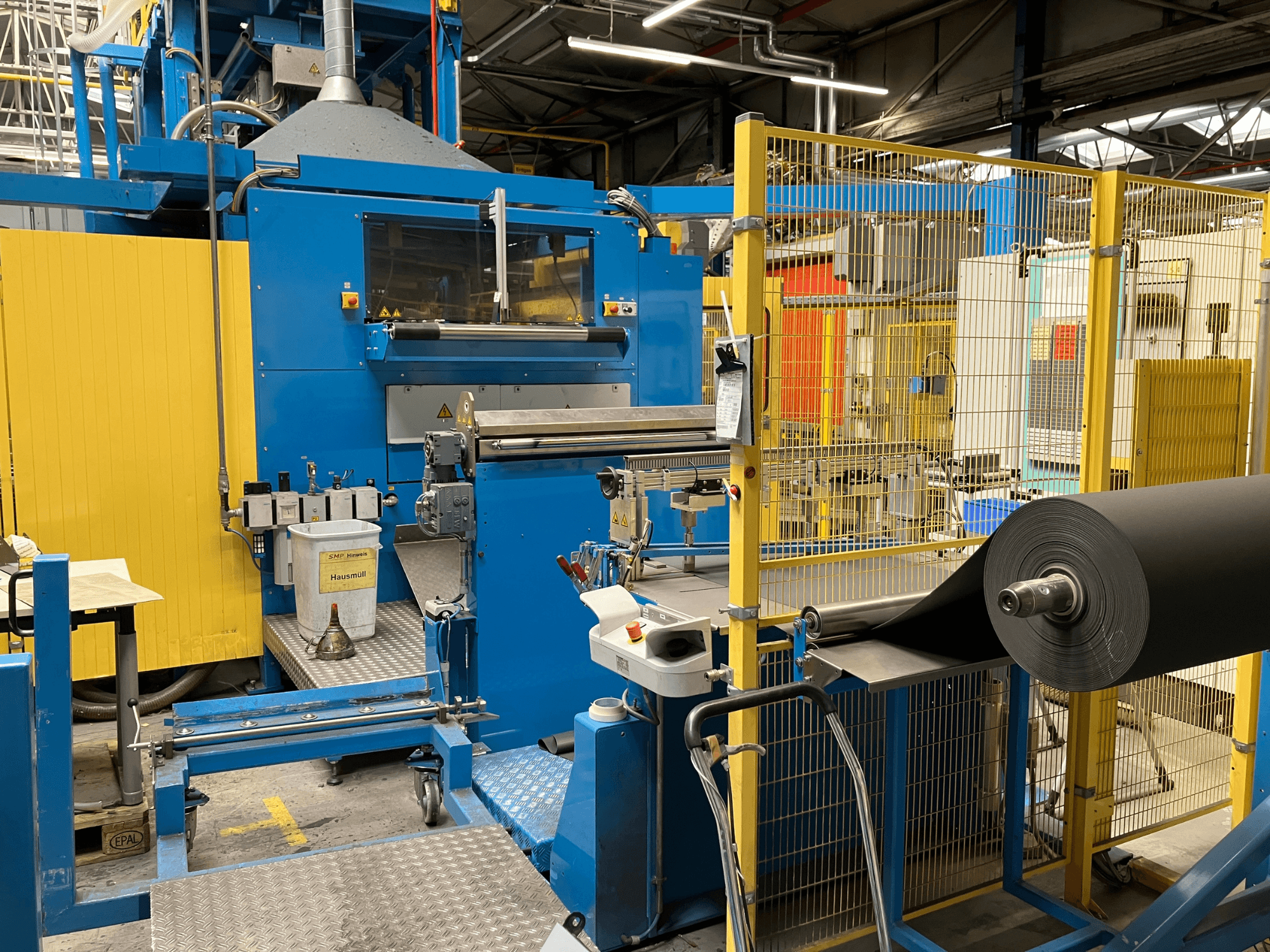 Machine de transformation du plastique KIEFEL KLS 86/235 vue de face, avec un rouleau de matériau noir et un panneau de commande.